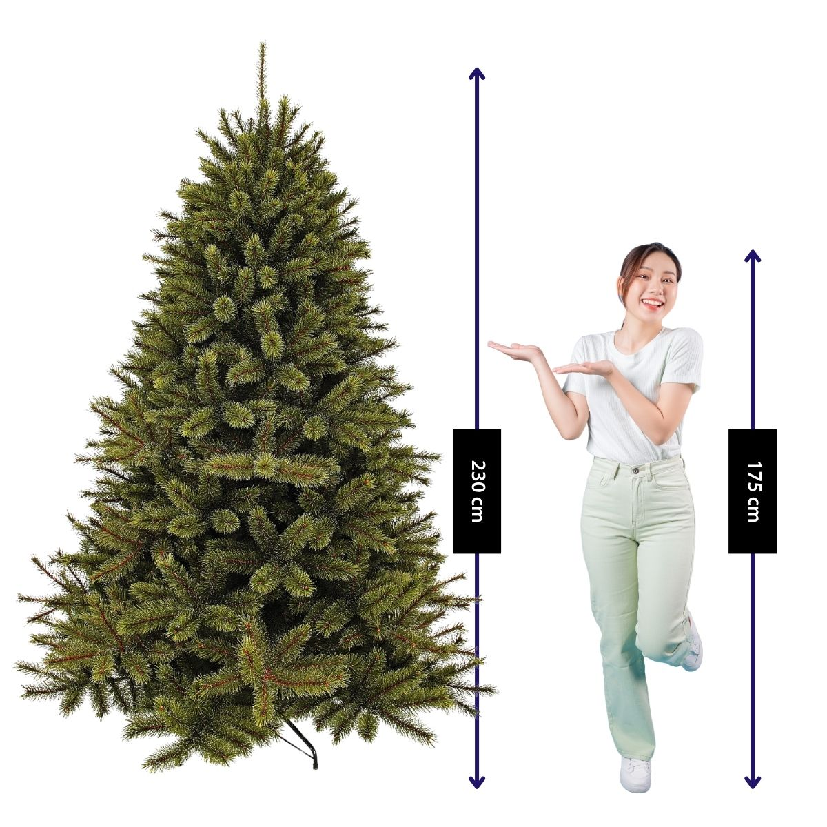 A woman in a white shirt and green pants stands next to a 230 cm artificial Christmas tree.