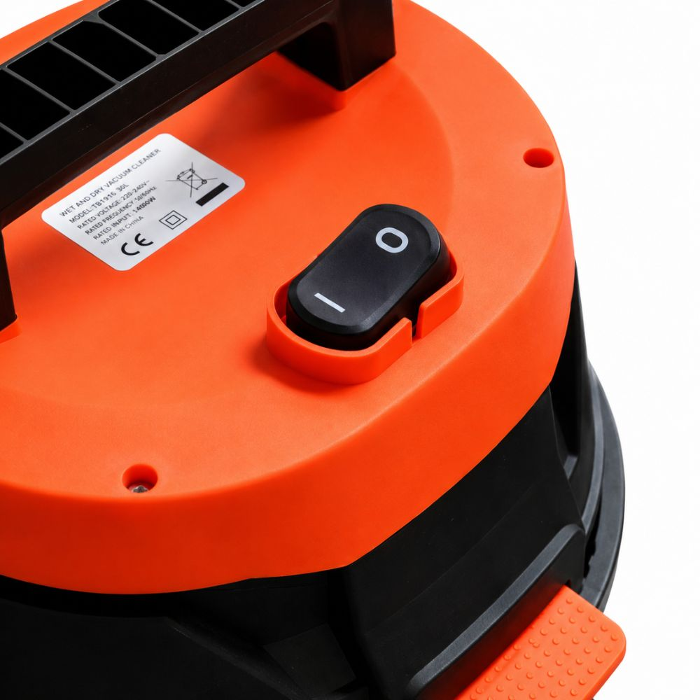 Primer plano de la parte superior del aspirador naranja y negro con interruptor.