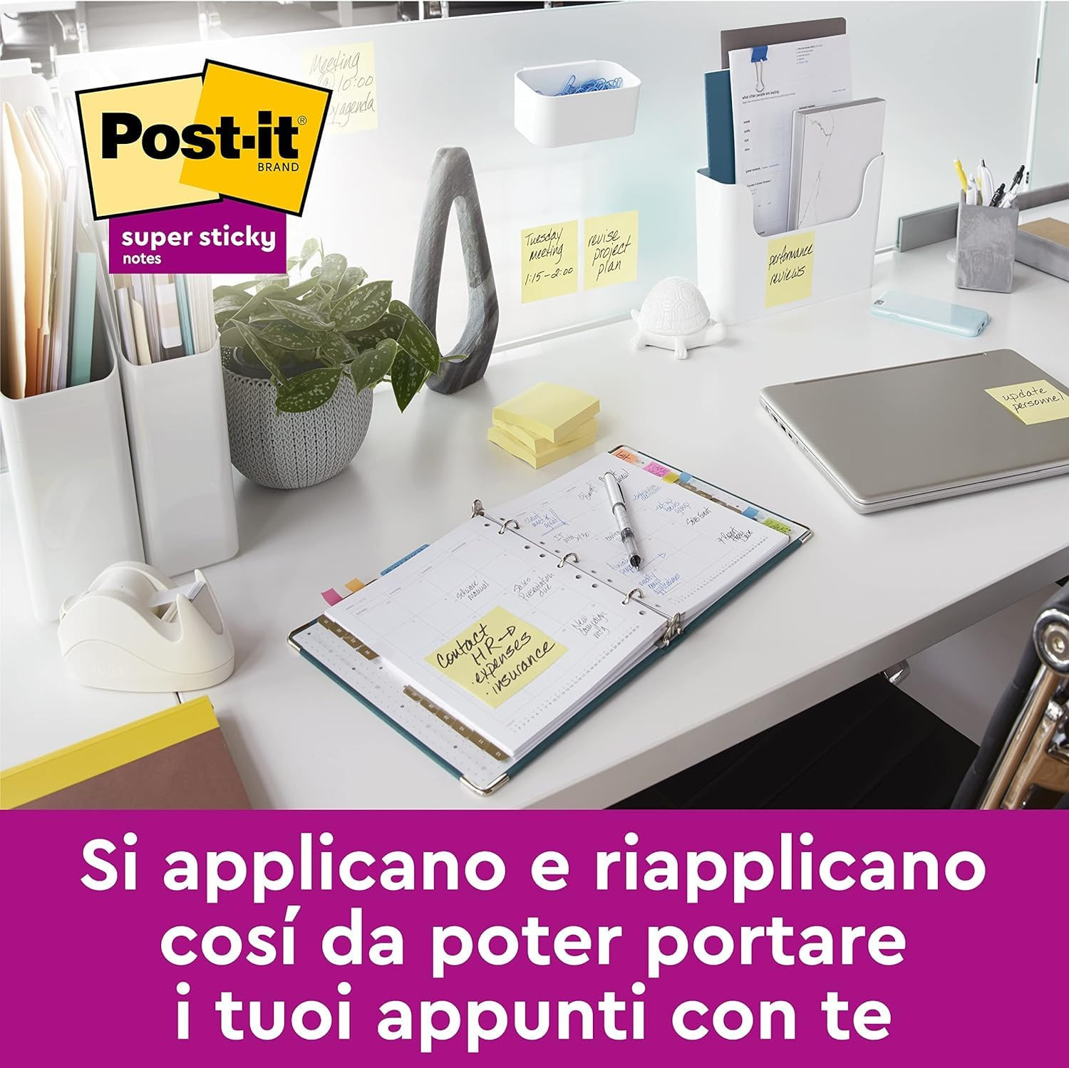 Una scrivania ordinata con laptop, agenda aperta, note Post-it, pianta e materiale.