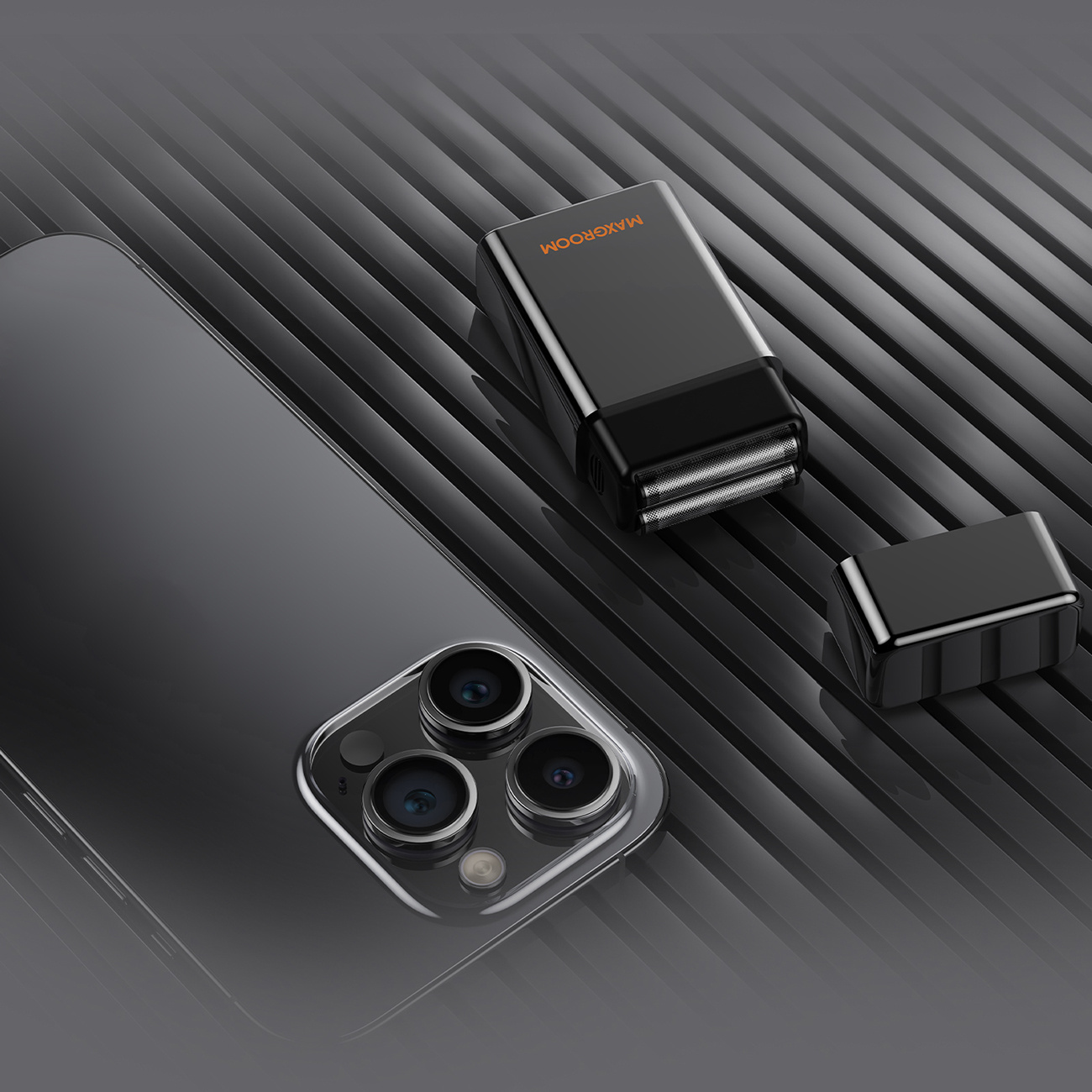 Uno smartphone e un rasoio elettrico nero compatto poggiano su una superficie scanalata.