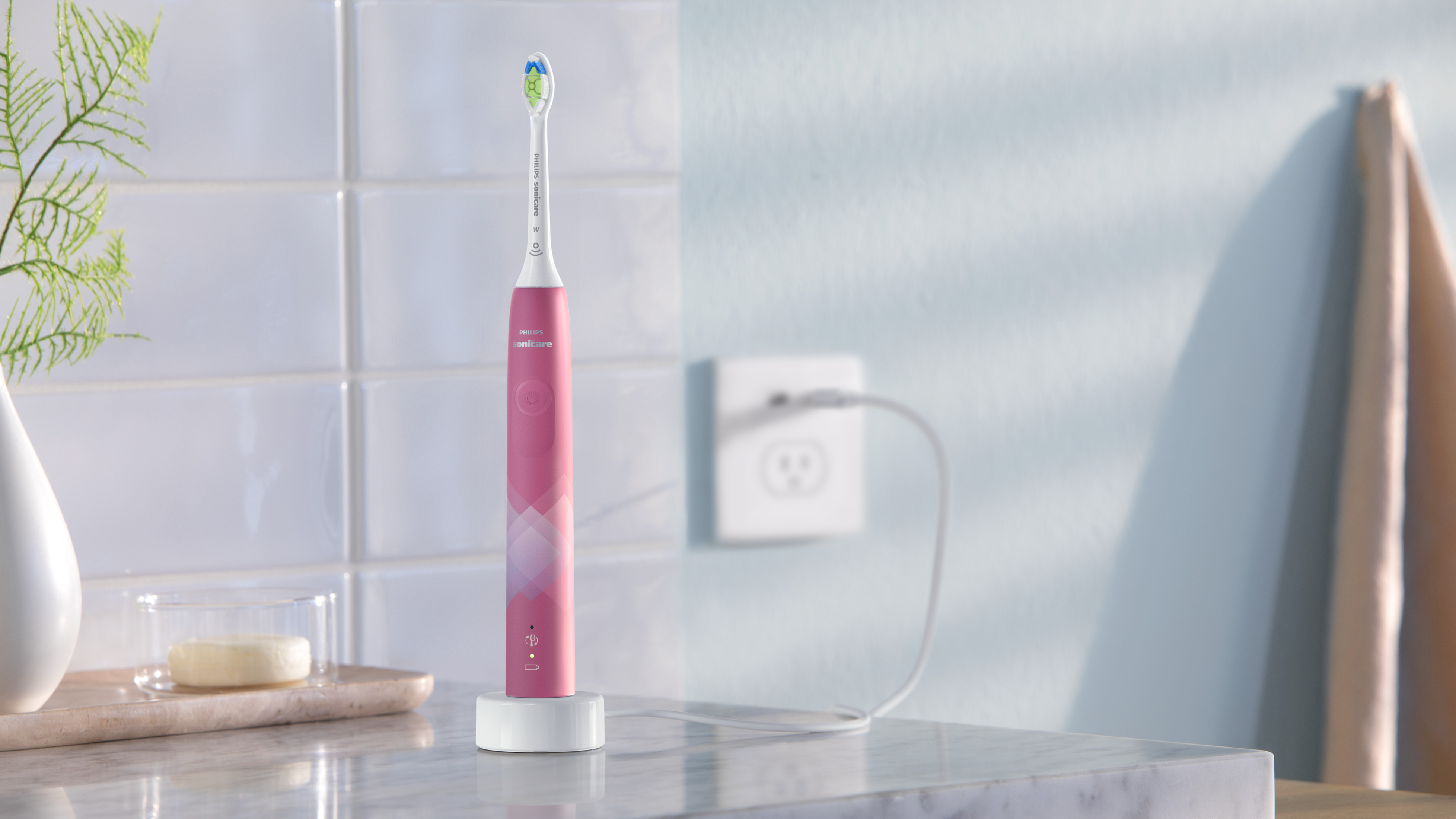 Uno spazzolino elettrico Philips Sonicare rosa su una base di carica in un bagno.