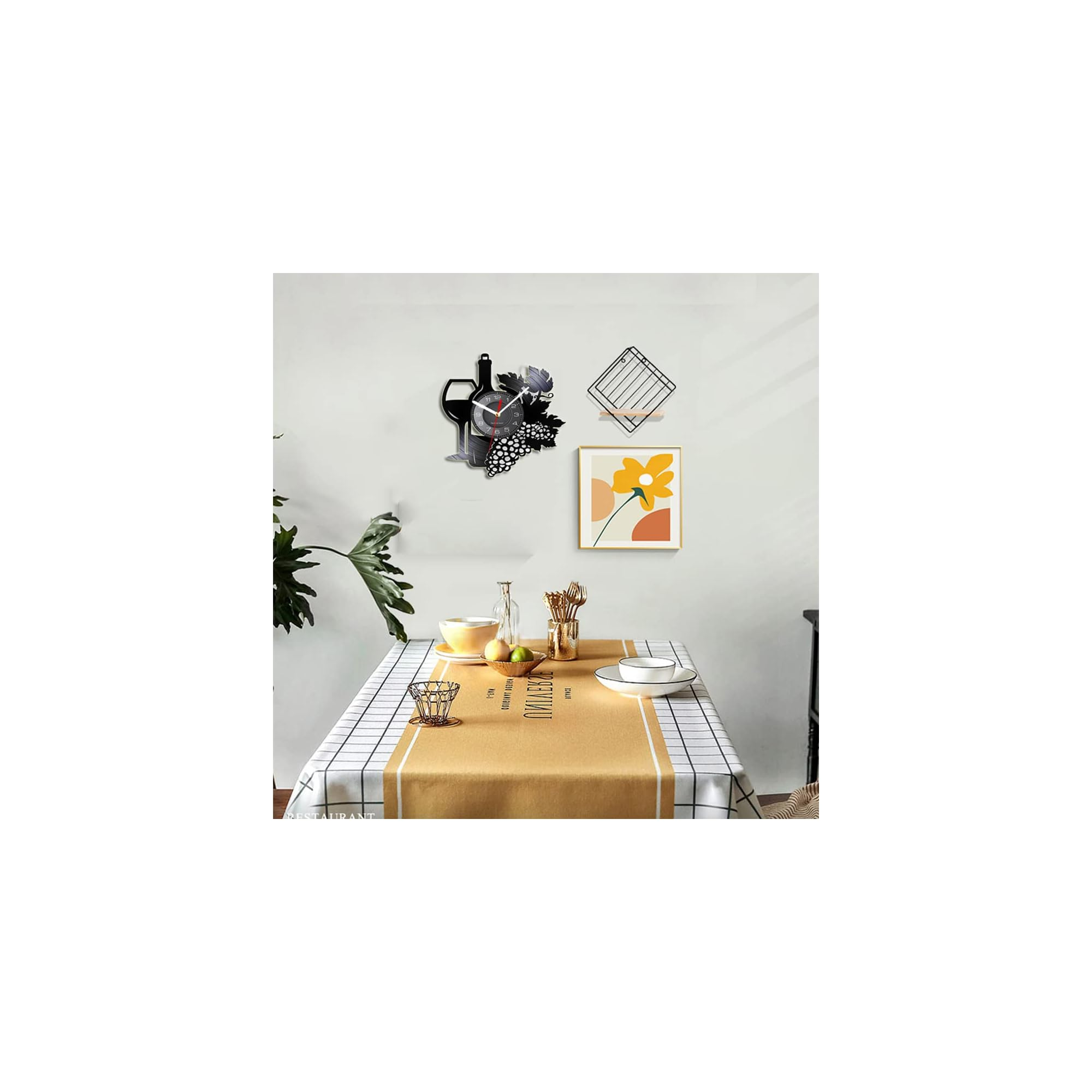 Ein gedeckter Esstisch mit karoartiger Decke und gelbem Läufer; an der Wand hängen eine Weinuhr und ein Blumenbild.