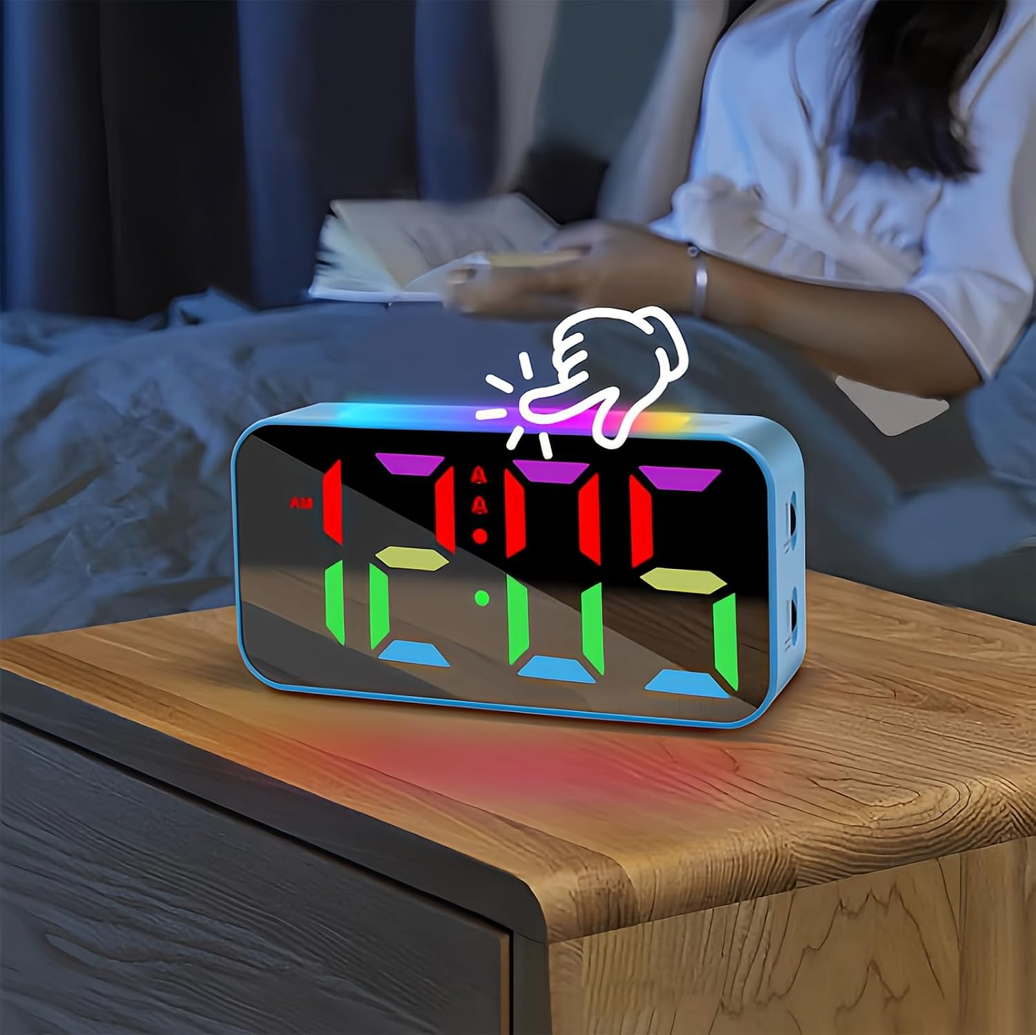 Ein digitaler Wecker mit buntem LED-Display steht auf einem Nachttisch, im Hintergrund sitzt eine Person.