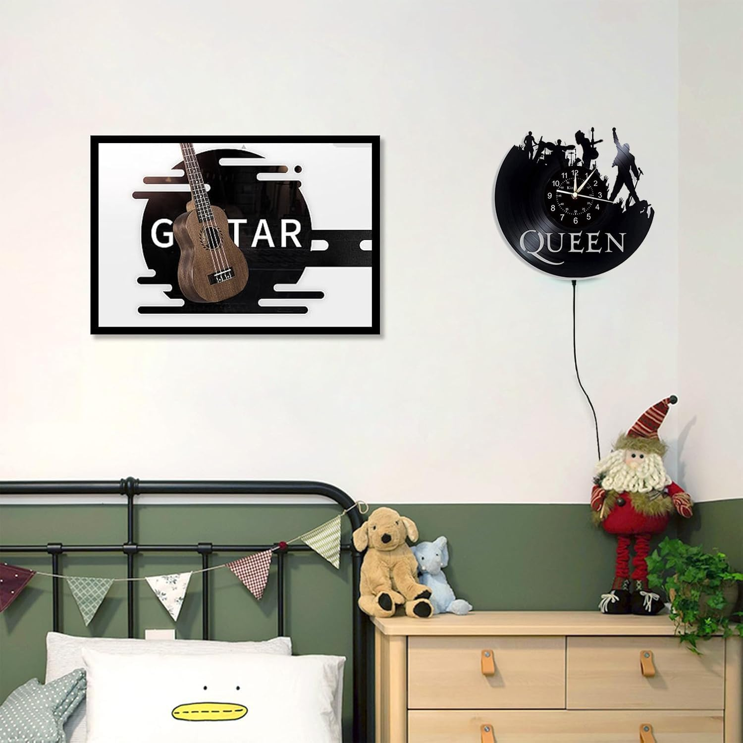 Wand mit Gitarrenbild, Queen-Vinyluhr, Weihnachtsfigur und Plüschtieren über einem Bett.