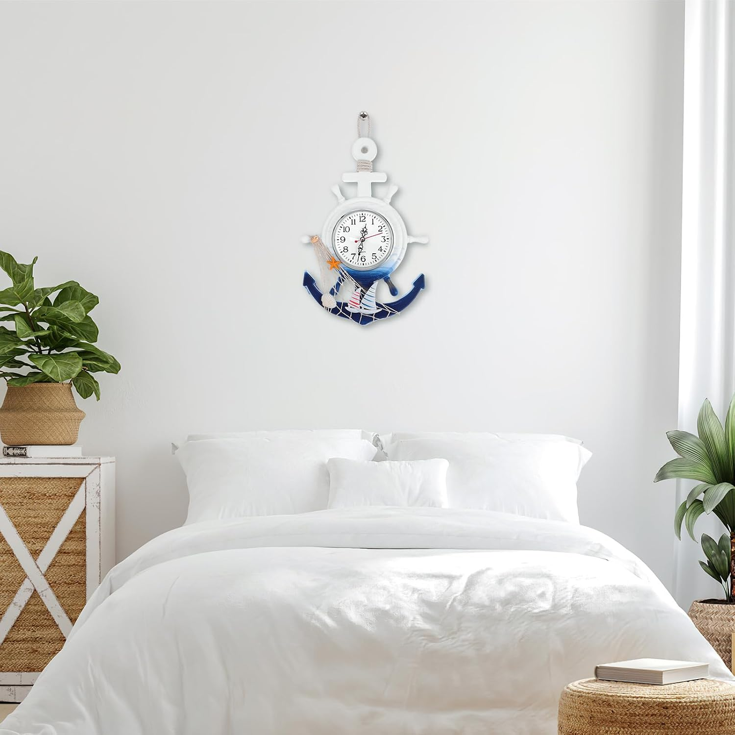 Ein weißes Schlafzimmer hat ein Bett mit weißer Bettwäsche und eine nautische Ankeruhr an der Wand.