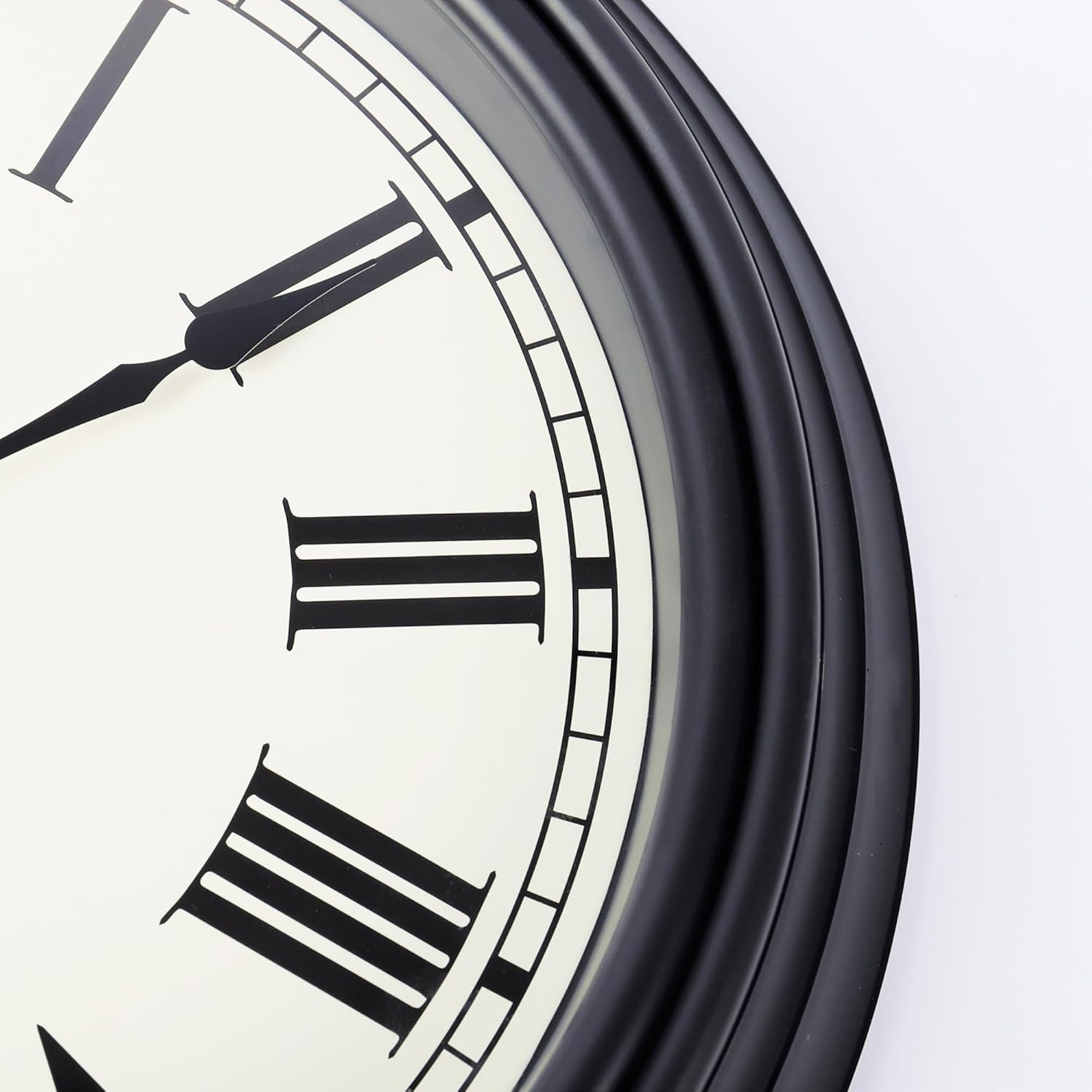 Nahaufnahme einer Wanduhr mit schwarzem Rahmen, weißem Zifferblatt, schwarzen römischen Ziffern und Zeigern.