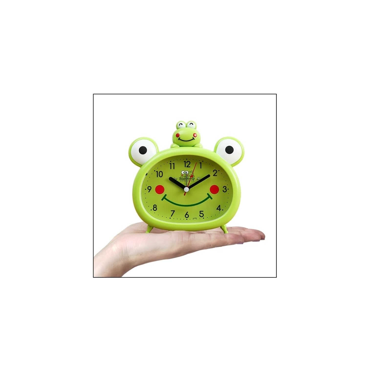 Eine Hand hält einen niedlichen, grünen Wecker in Froschform mit großen Augen und einem lächelnden Zifferblatt.