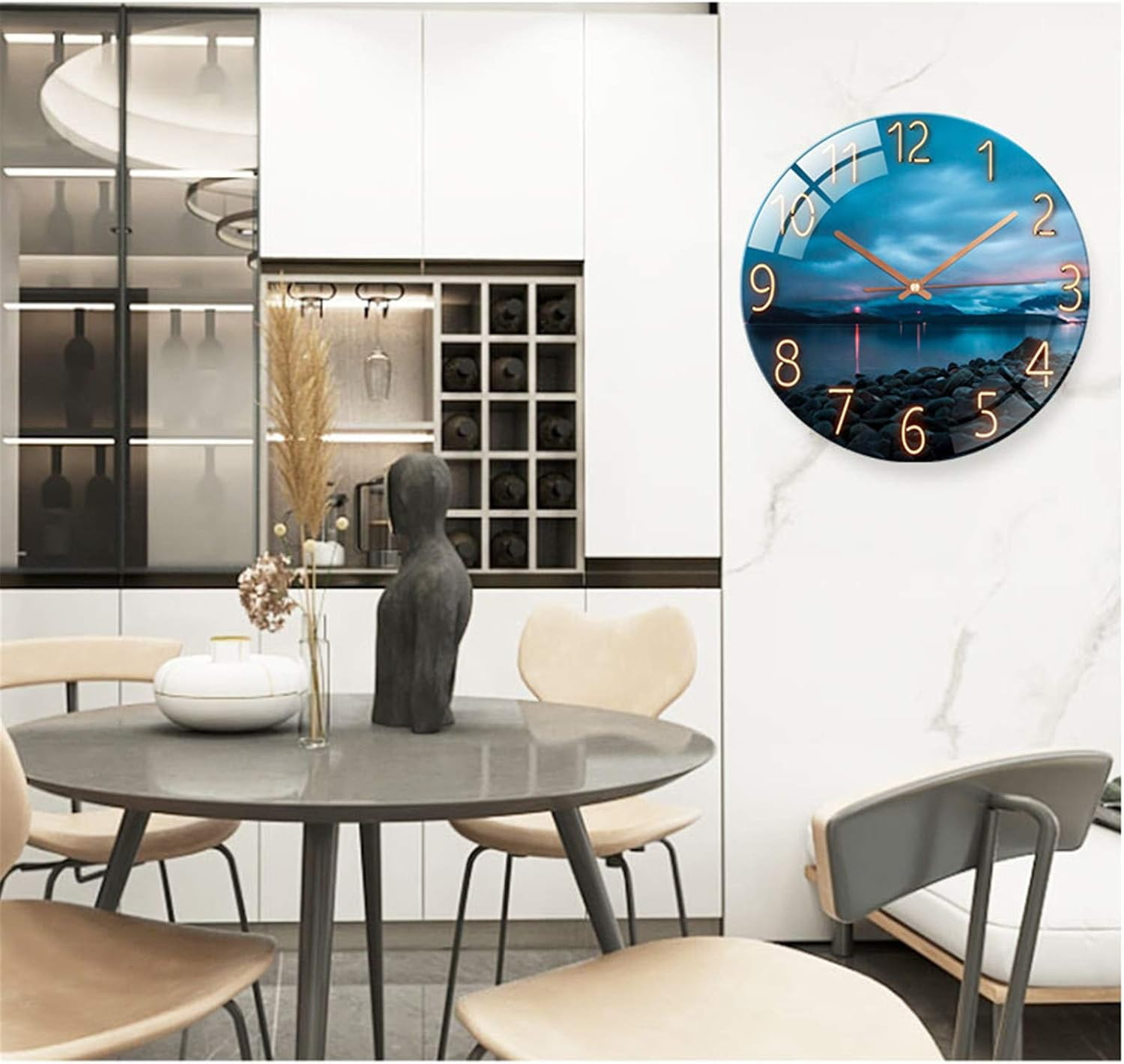 Eine runde Wanduhr mit Landschaftsmotiv hängt in einem modernen Esszimmer über einem Tisch mit Stühlen.