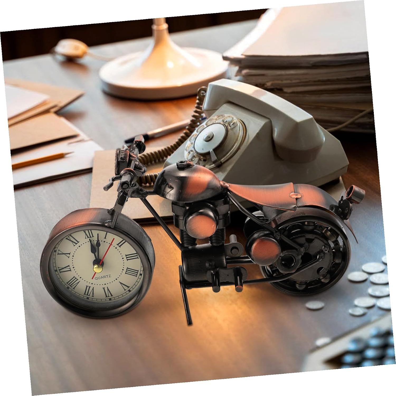 Ein Motorrad-Modell mit Vorderrad-Uhr auf einem Schreibtisch mit Telefon.