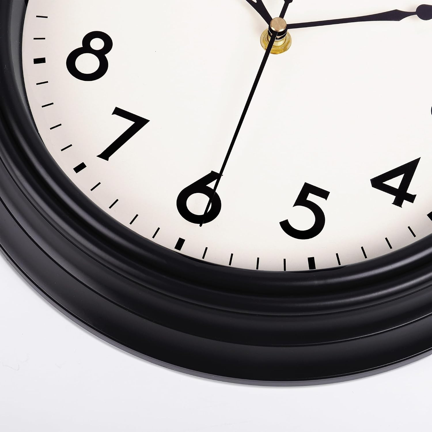 Nahaufnahme einer runden Wanduhr mit schwarzem Rahmen, weißem Zifferblatt und Ziffern von 4 bis 8.