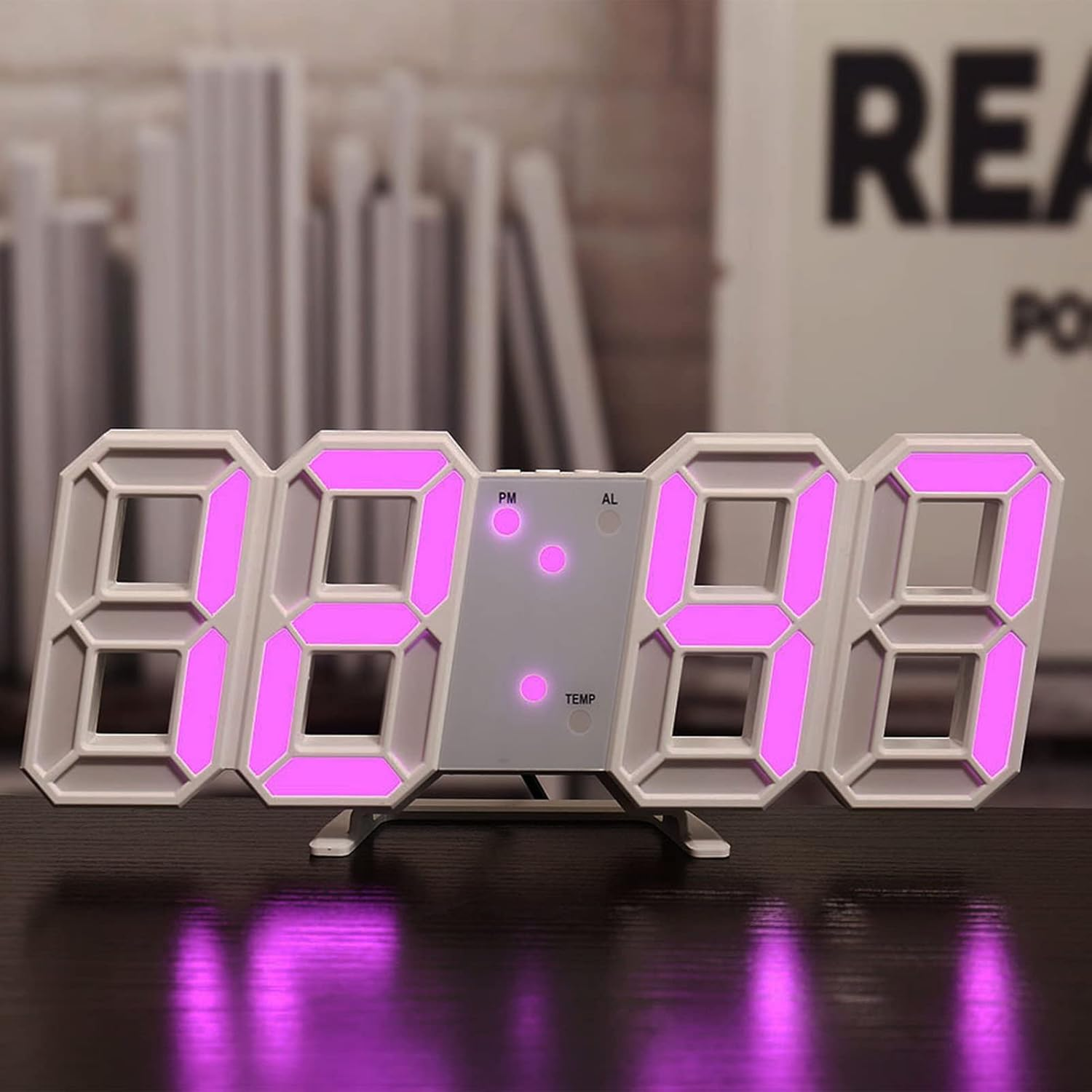 Eine moderne 3D-Digitaluhr auf dunkler Oberfläche mit hellrosa leuchtenden Ziffern.