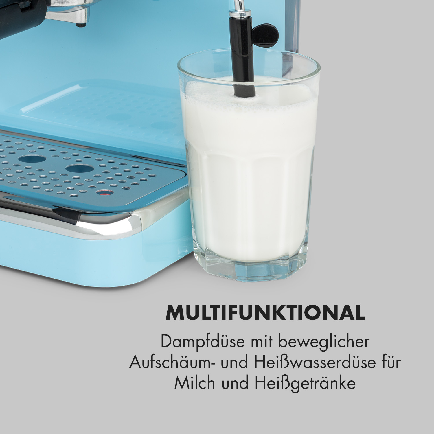 Blaue Kaffeemaschine mit einer Dampfdüse in einem Glas Milch.