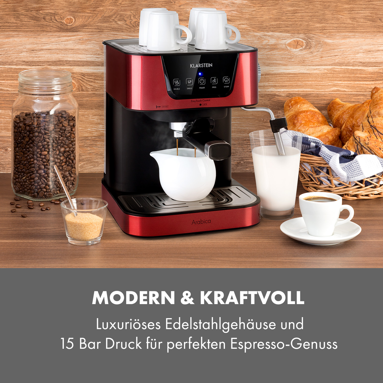Rote Kaffeemaschine auf Holz, mit Tassen, Bohnenglas, Milch und Croissants daneben.