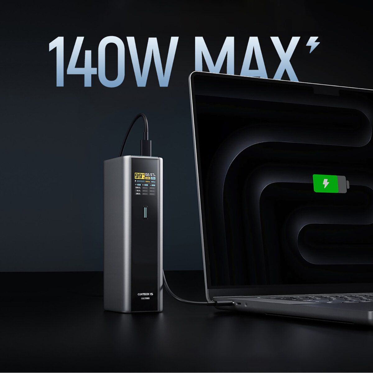 Eine graue Powerbank mit LCD-Display lädt einen Laptop auf, der Text lautet 140W MAX.