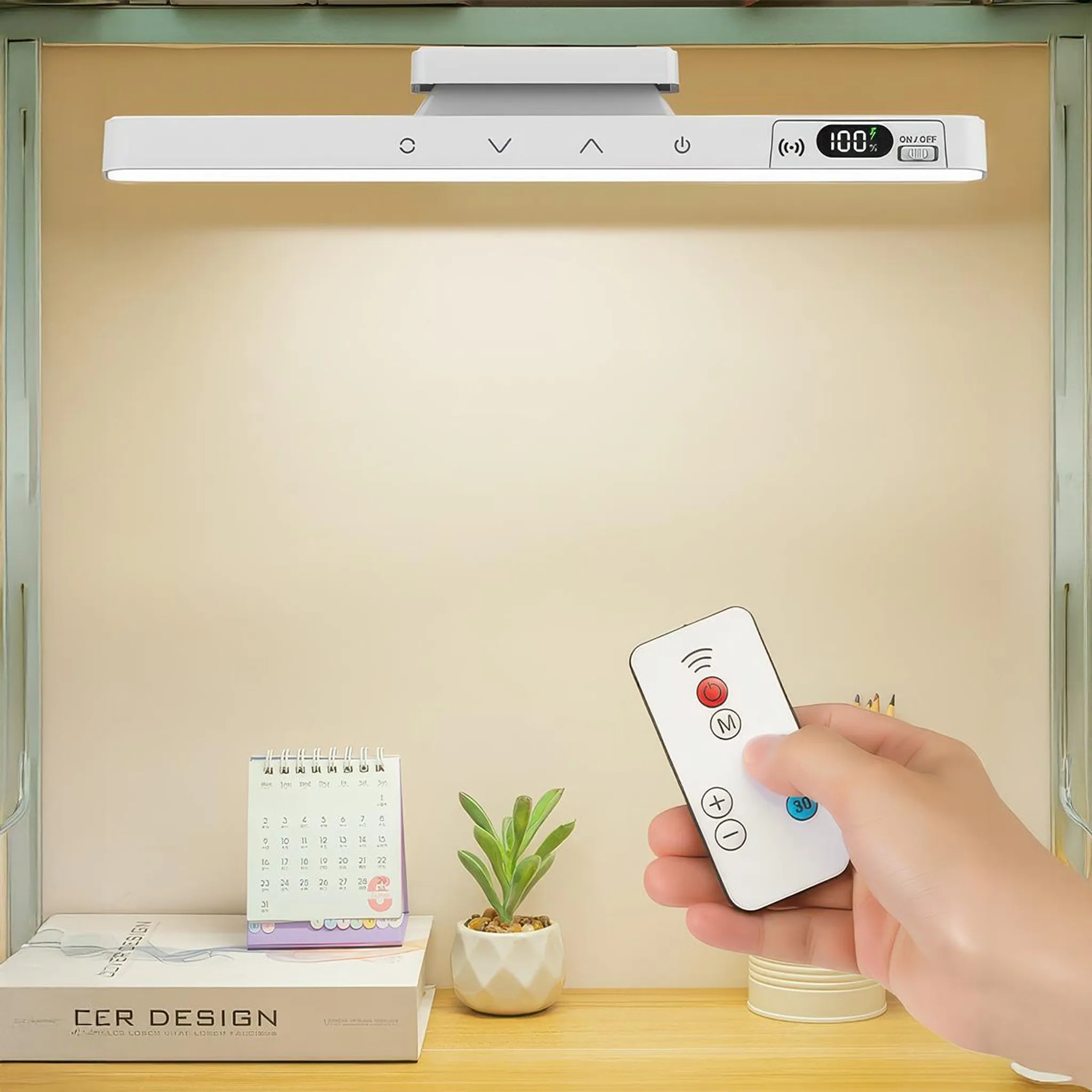 Eine Hand hält eine weiße Fernbedienung vor einer LED-Leuchte, einem Kalender und einer kleinen Pflanze auf einem Schreibtisch.