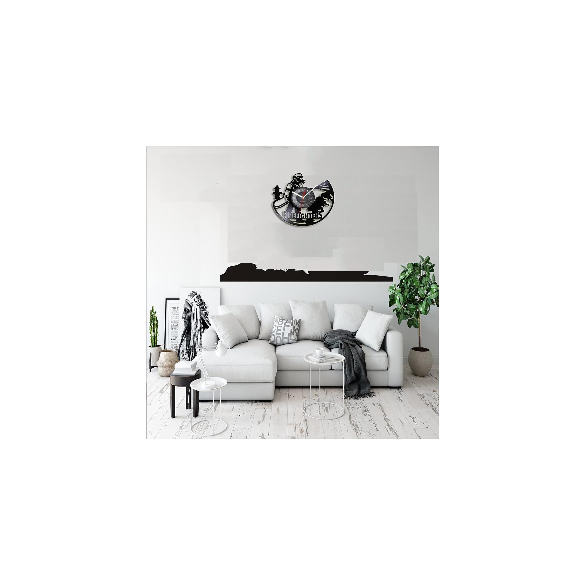 Wohnzimmer mit hellem Sofa, Tischen, Pflanzen und einer Feuerwehr-Wimmuhr an der weißen Wand.
