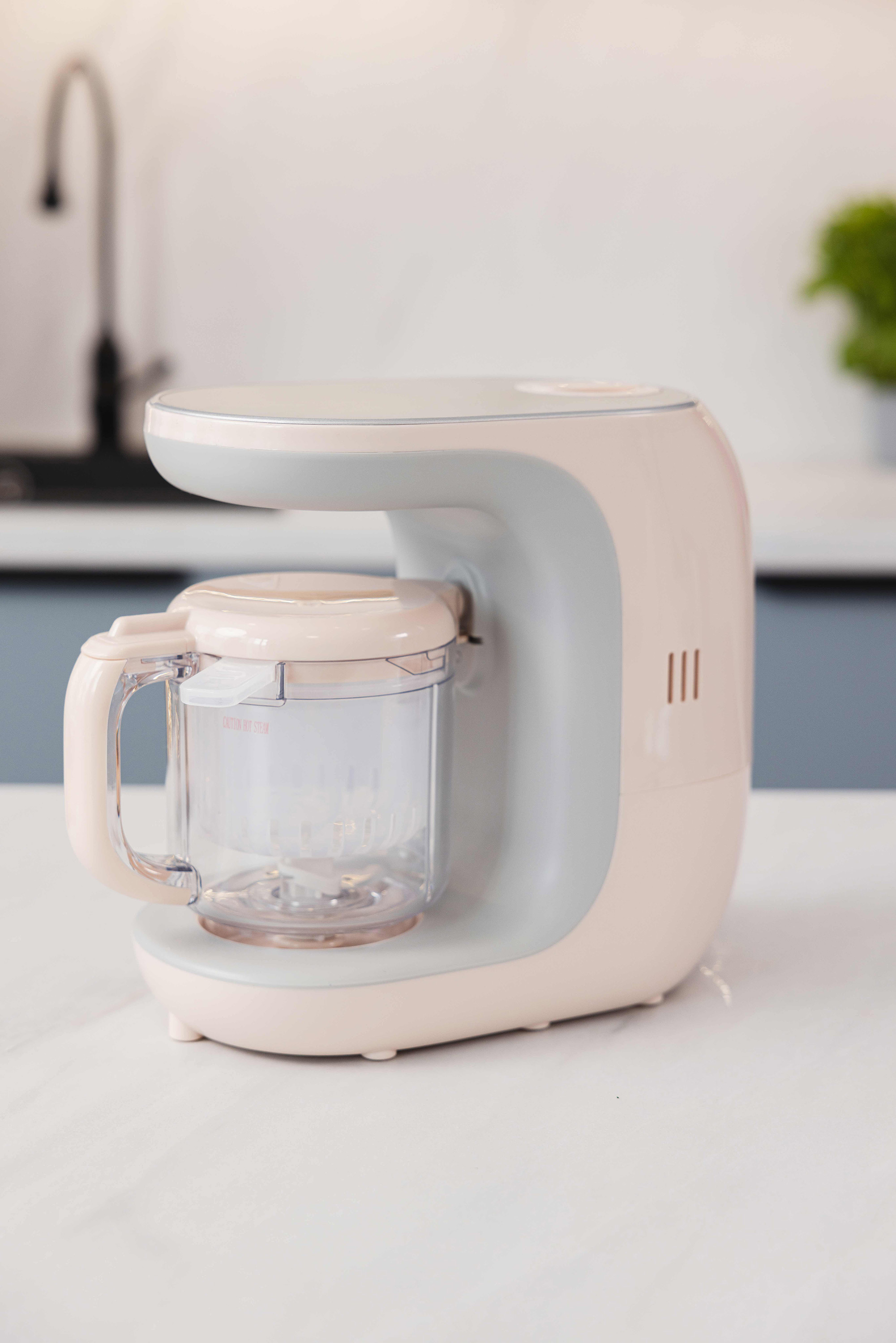 Un cuocipappa bianco e grigio su un bancone bianco in una cucina moderna.