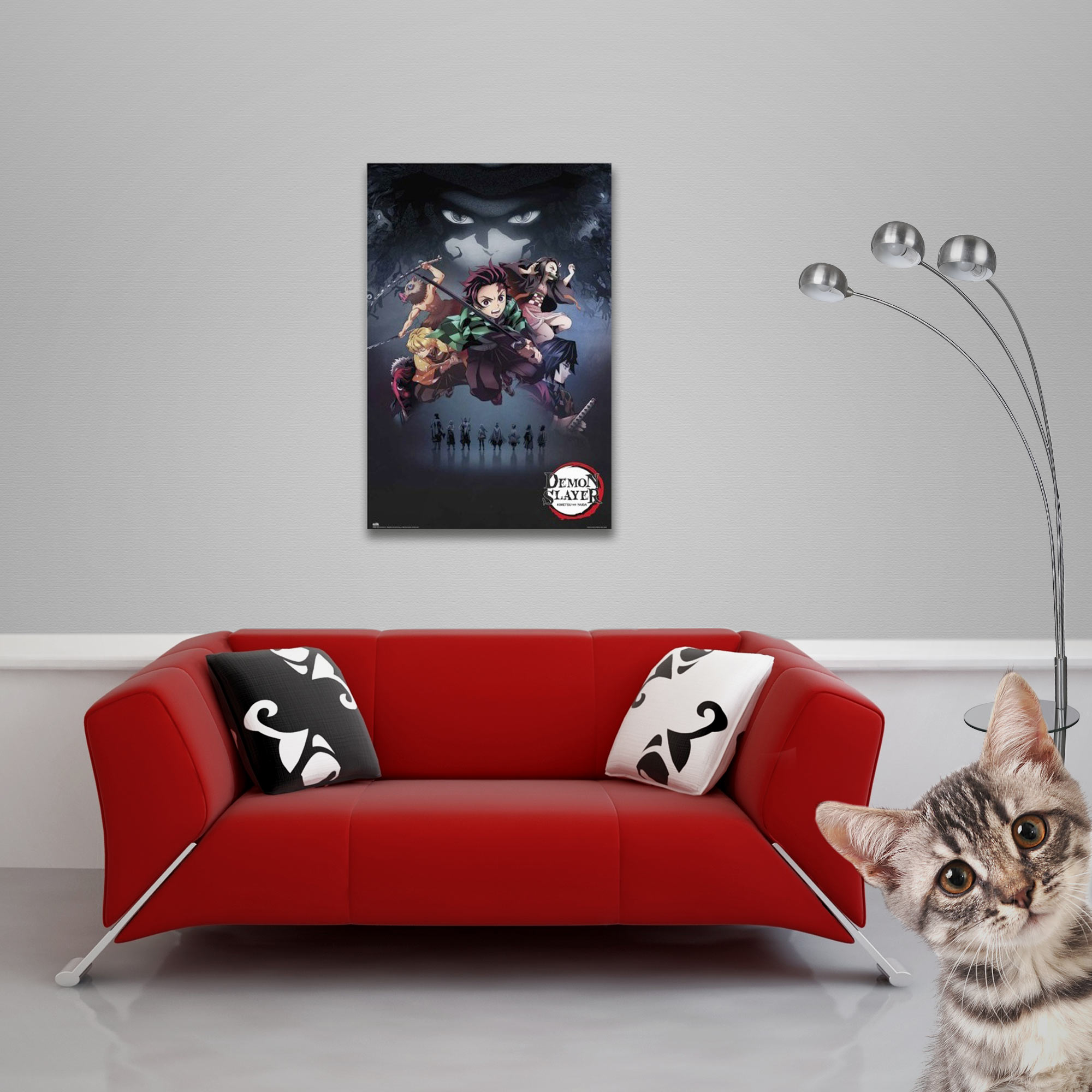 Ein rotes Sofa mit Kissen unter einem Plakat an einer grauen Wand, neben Lampe und Katze.