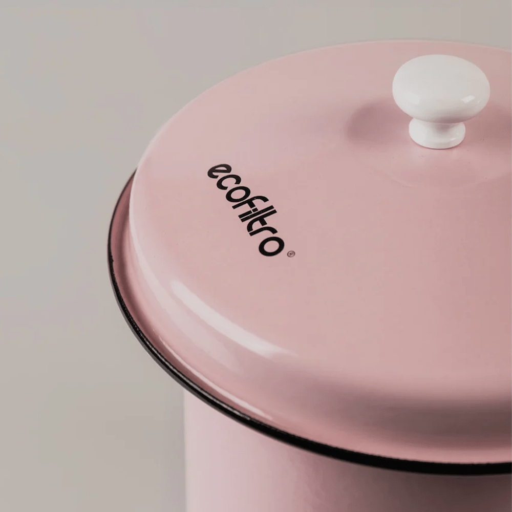 Un contenitore rosa con la scritta ecofiltro e un pomello bianco sul coperchio.