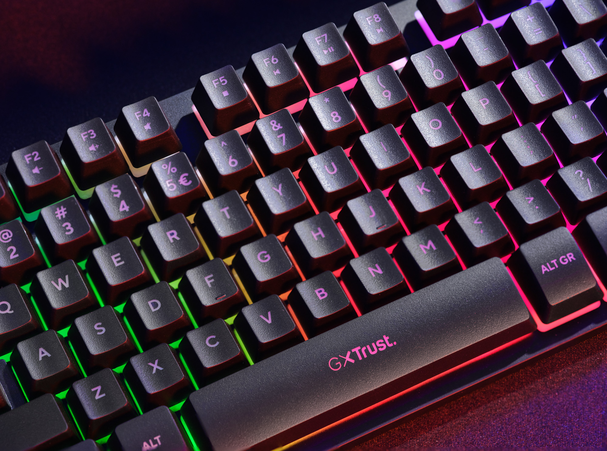 Eine Nahaufnahme einer schwarzen Gaming-Tastatur mit lebendiger RGB-Hintergrundbeleuchtung in Regenbogenfarben.