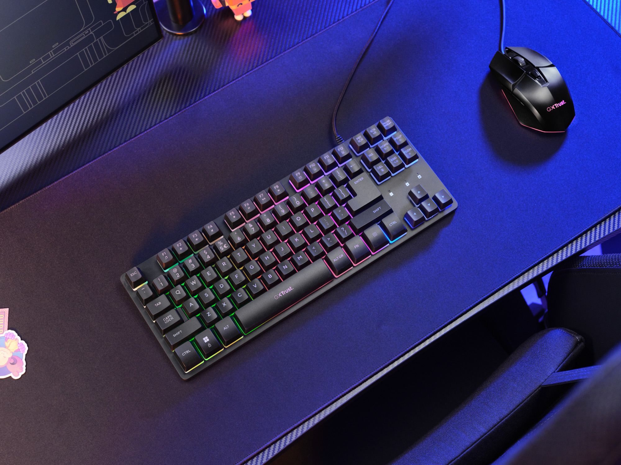 Eine schwarze mechanische Tastatur mit RGB-Beleuchtung und eine passende Computermaus liegen auf einem blauen Schreibtisch.