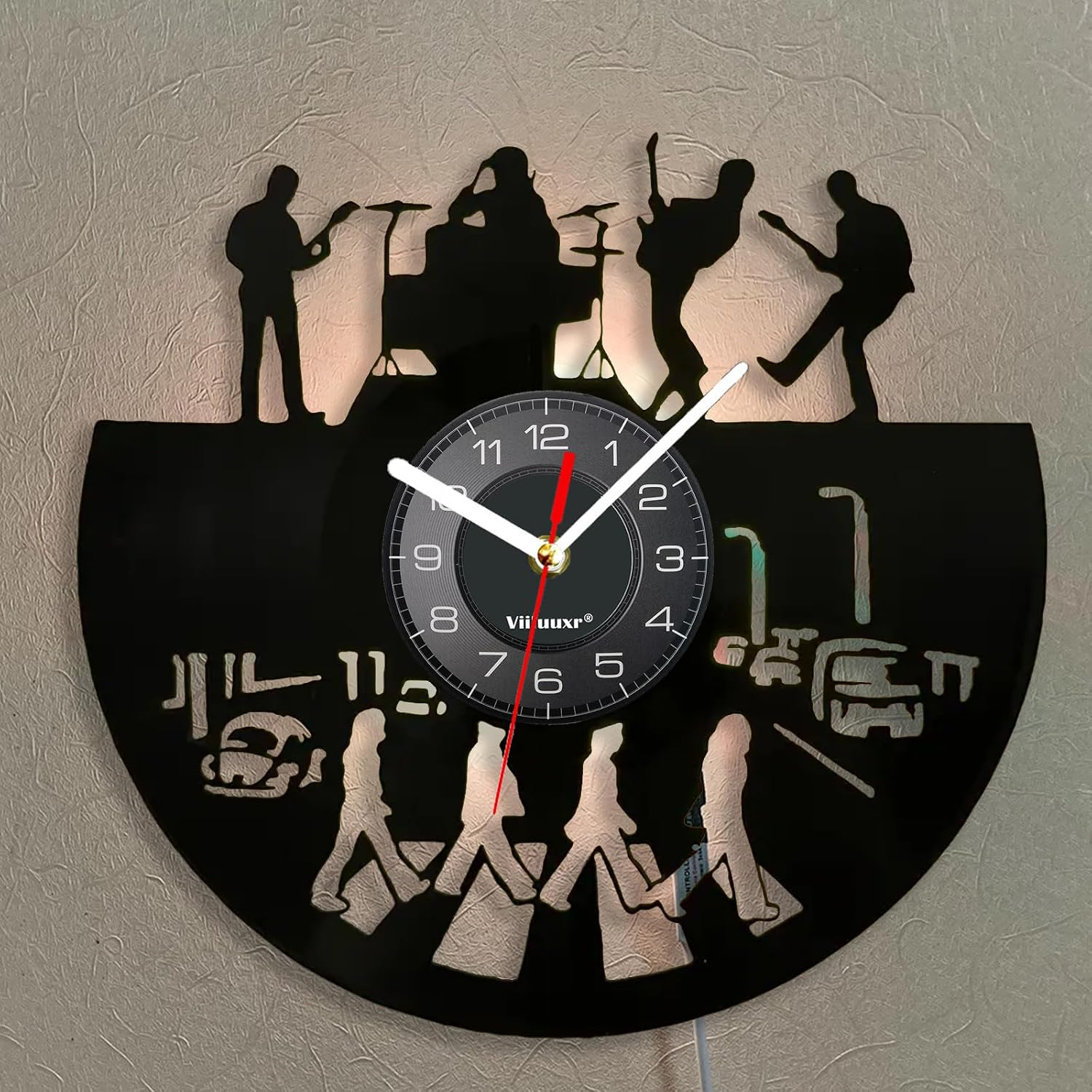 Wanduhr aus Vinyl mit Band-Silhouetten oben und den Beatles auf der Abbey Road unten.