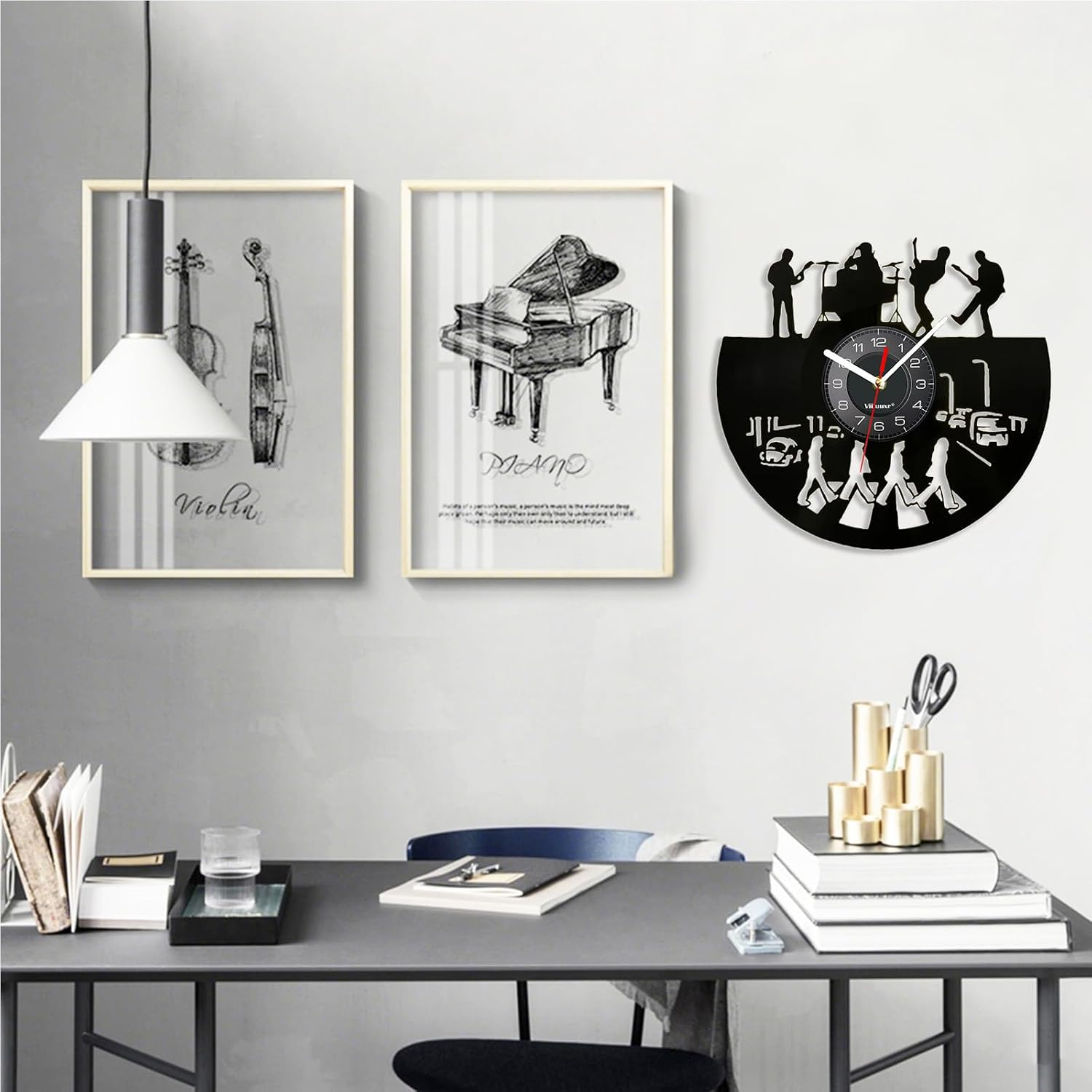 Ein Schreibtisch mit Büchern und Glas, gerahmte Musikbilder an der Wand und eine Band-Uhr.