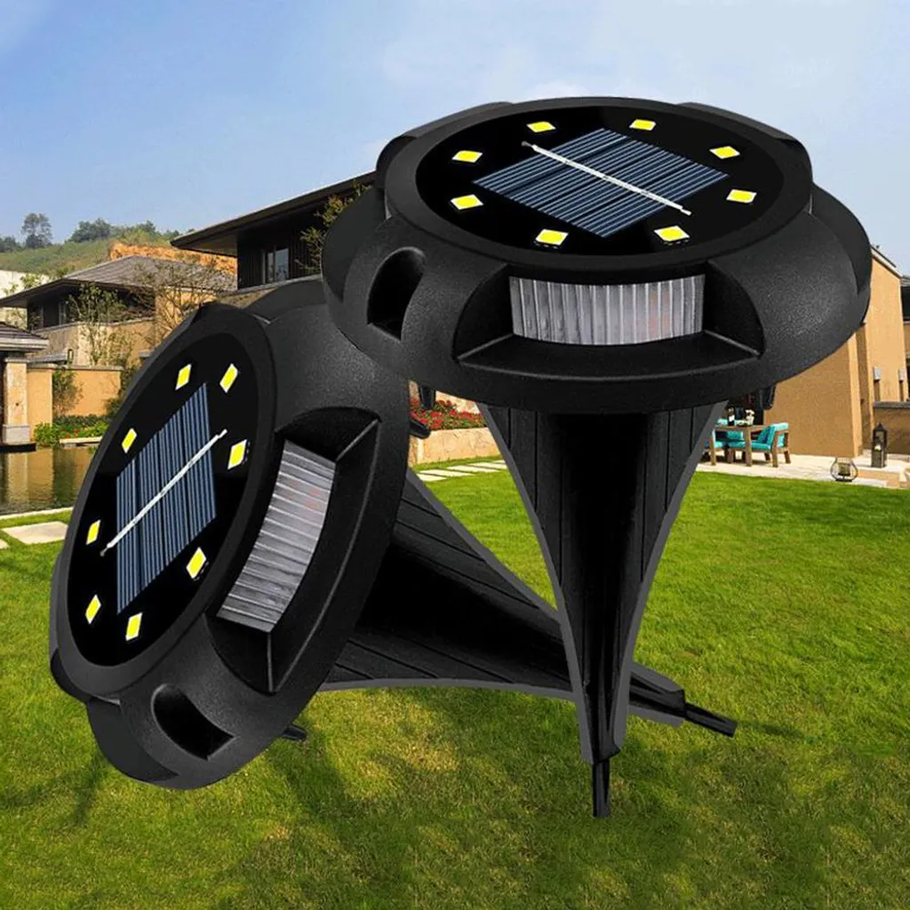 Zwei runde, schwarze Solarlampen für den Garten mit integrierten Solarzellen und LEDs auf Rasen.
