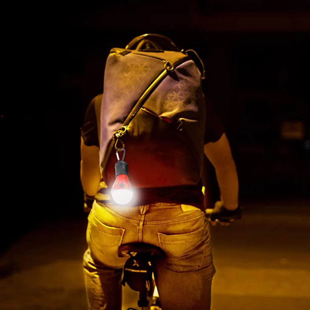 Radfahrer von hinten in der Nacht, mit hellem rotem Licht am Rucksack.