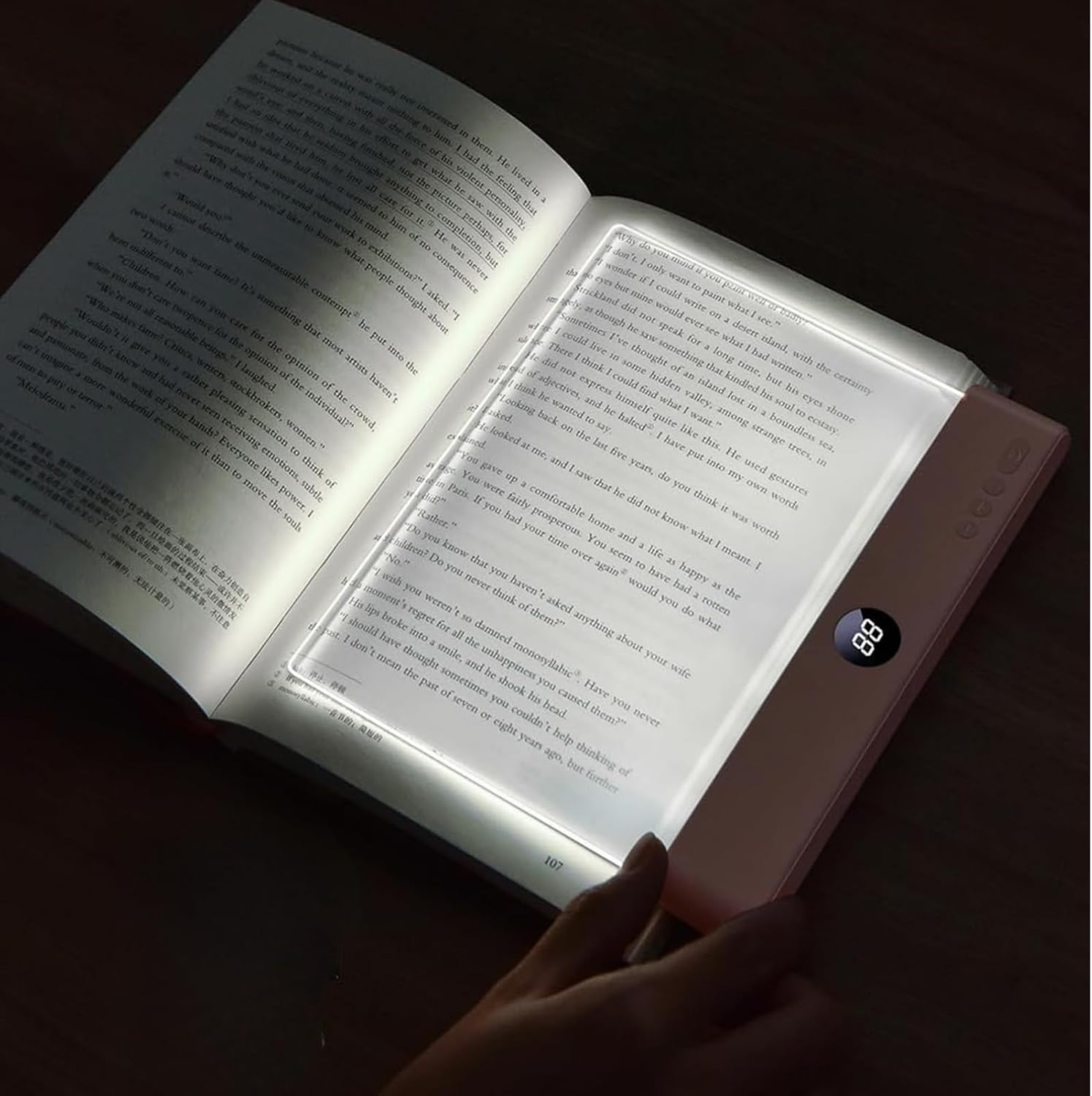 Ein beleuchtetes Lesegerät wird nachts in den Händen gehalten und zeigt gedruckten Text auf den Seiten.