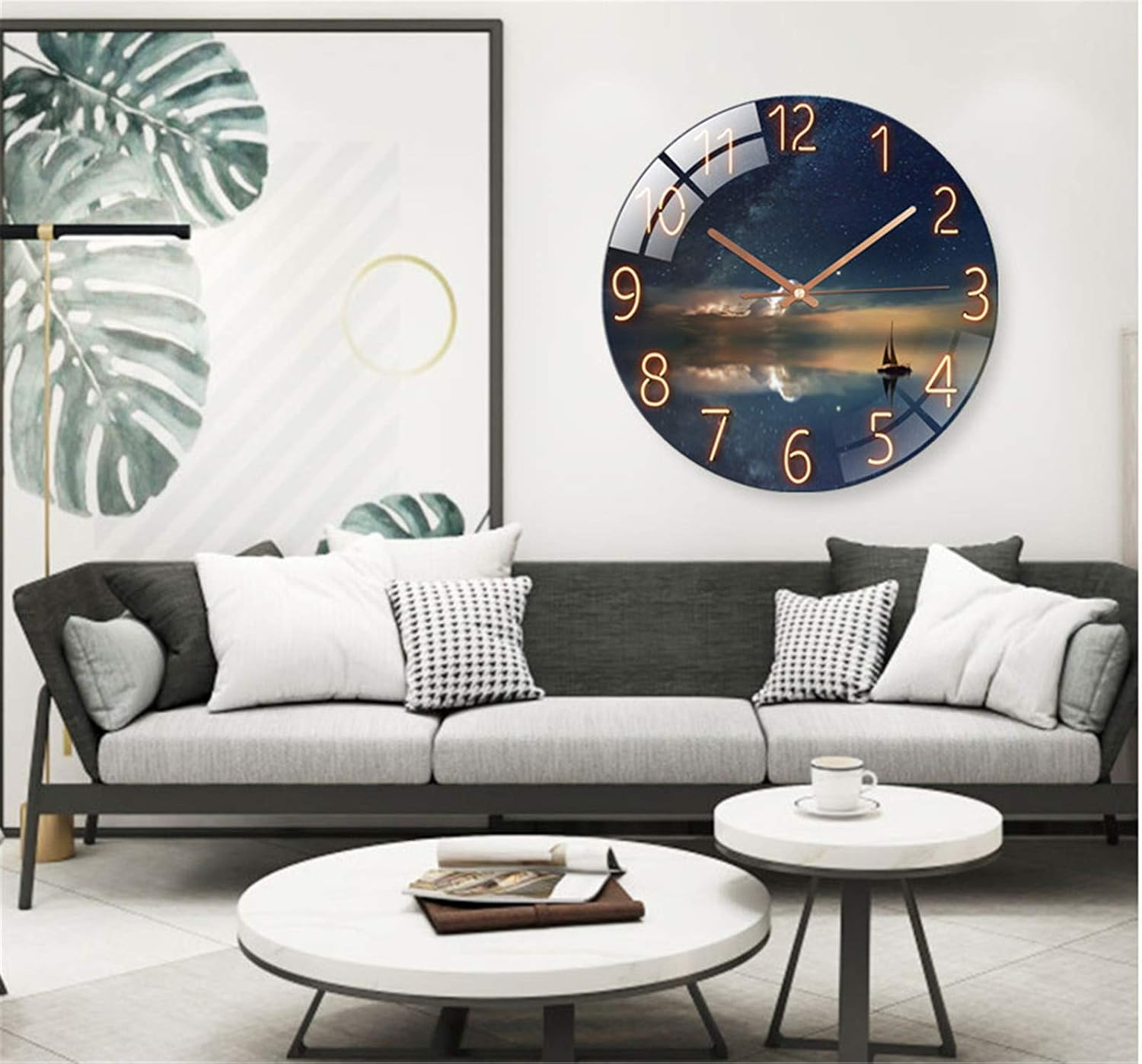 Wohnzimmer mit grauem Sofa, runden Tischen, grosser Wanduhr mit Nachthimmelmotiv und Pflanzenbild an der Wand.