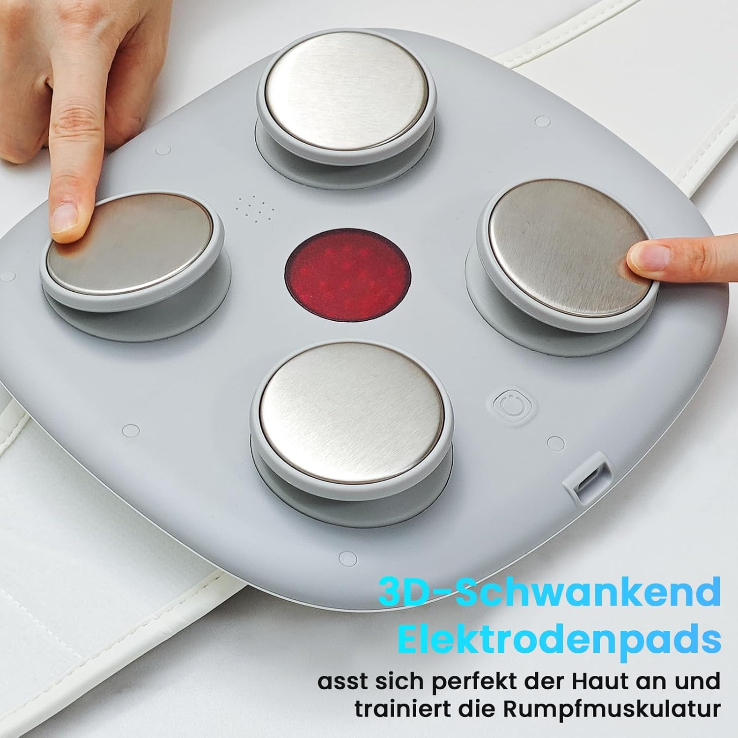 Graues Massagegerät mit vier runden Edelstahlkontakten und rotem Mittelpunkt, bedient von zwei Fingern.