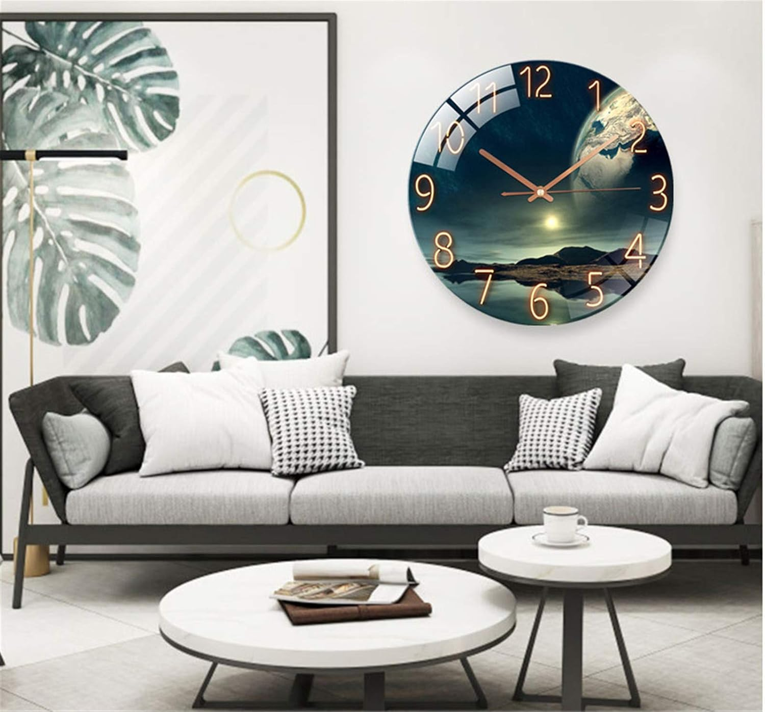 Wohnzimmer mit grauem Sofa, runden Tischen, grosser Blätterkunst und einer Wanduhr mit Weltraummotiv.