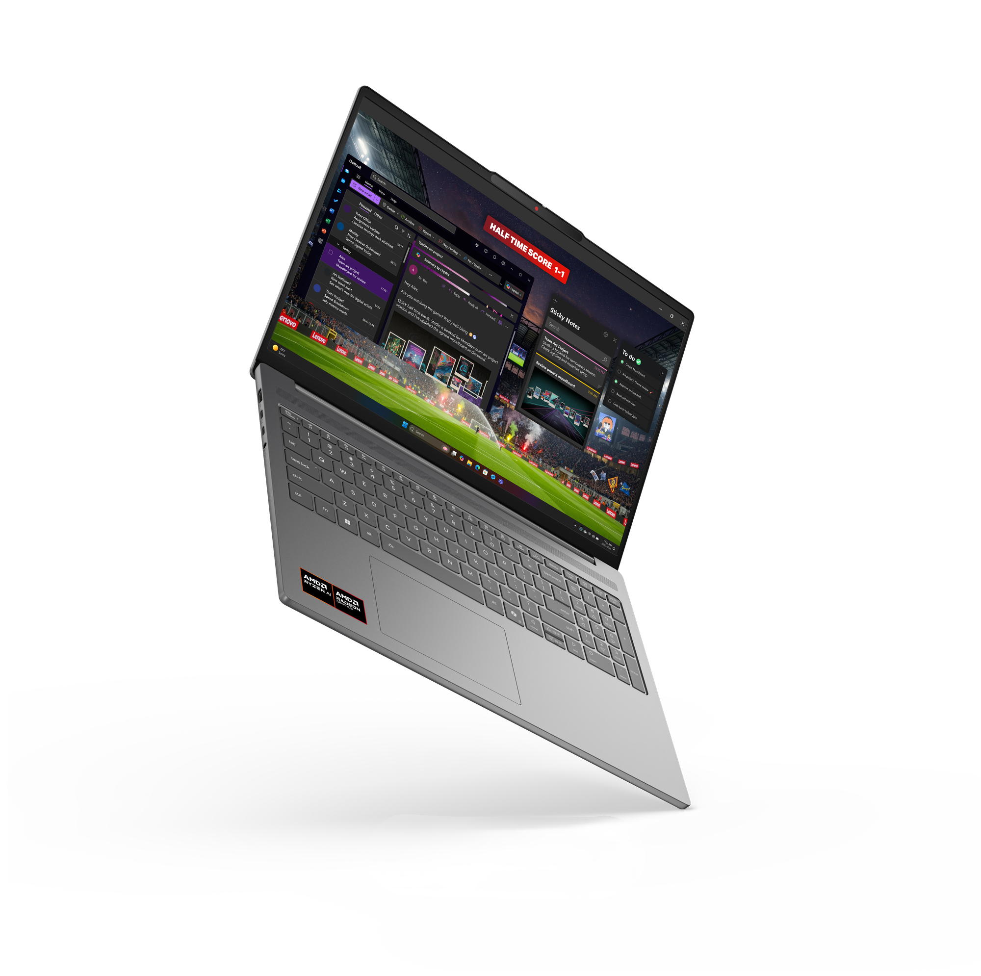 Ein leicht geneigter silberner Laptop zeigt eine Desktop-Oberfläche mit einem Fußballspiel und Apps.