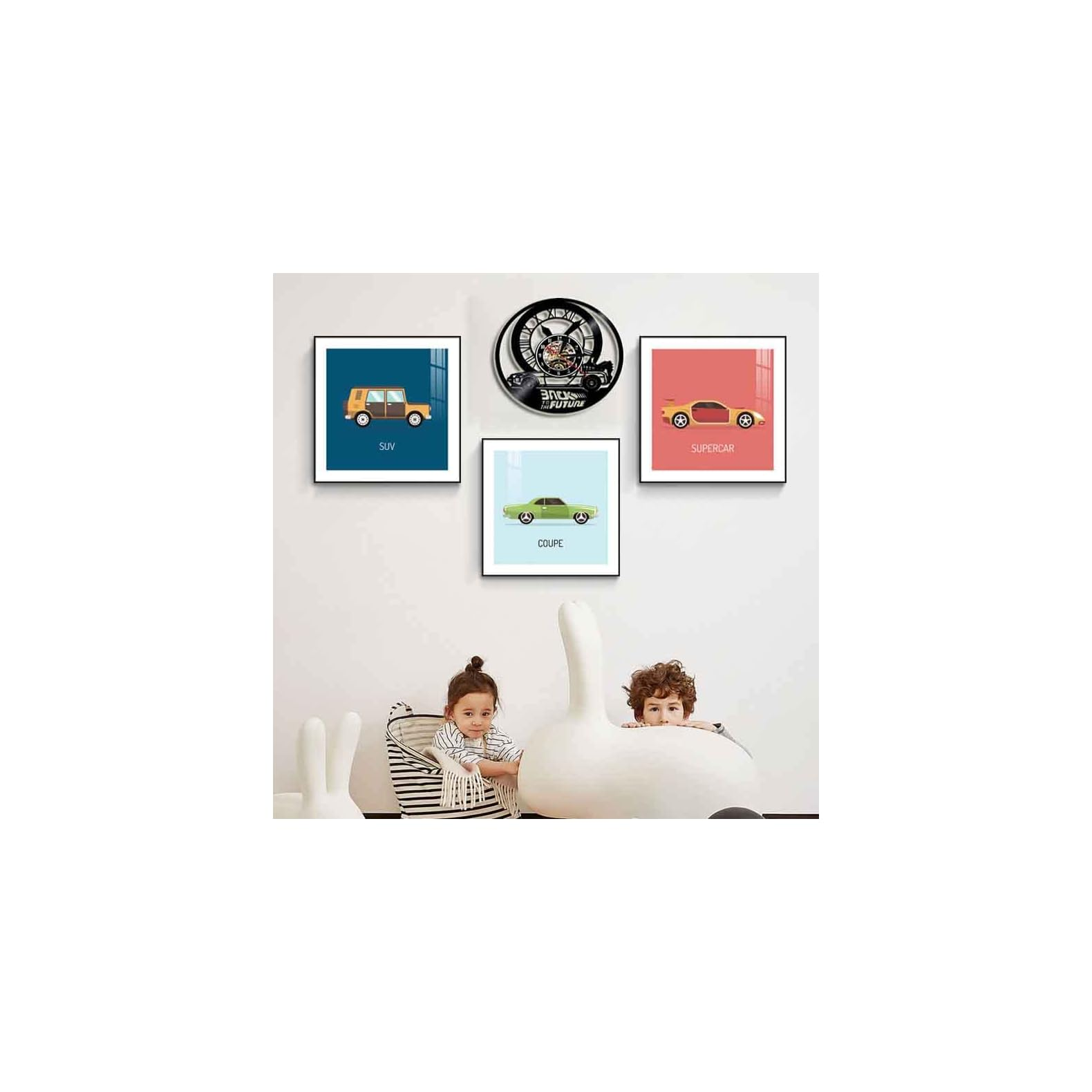 Zwei Kinder spielen in einem Zimmer, an dessen heller Wand drei Auto-Bilder und eine Uhr hängen.