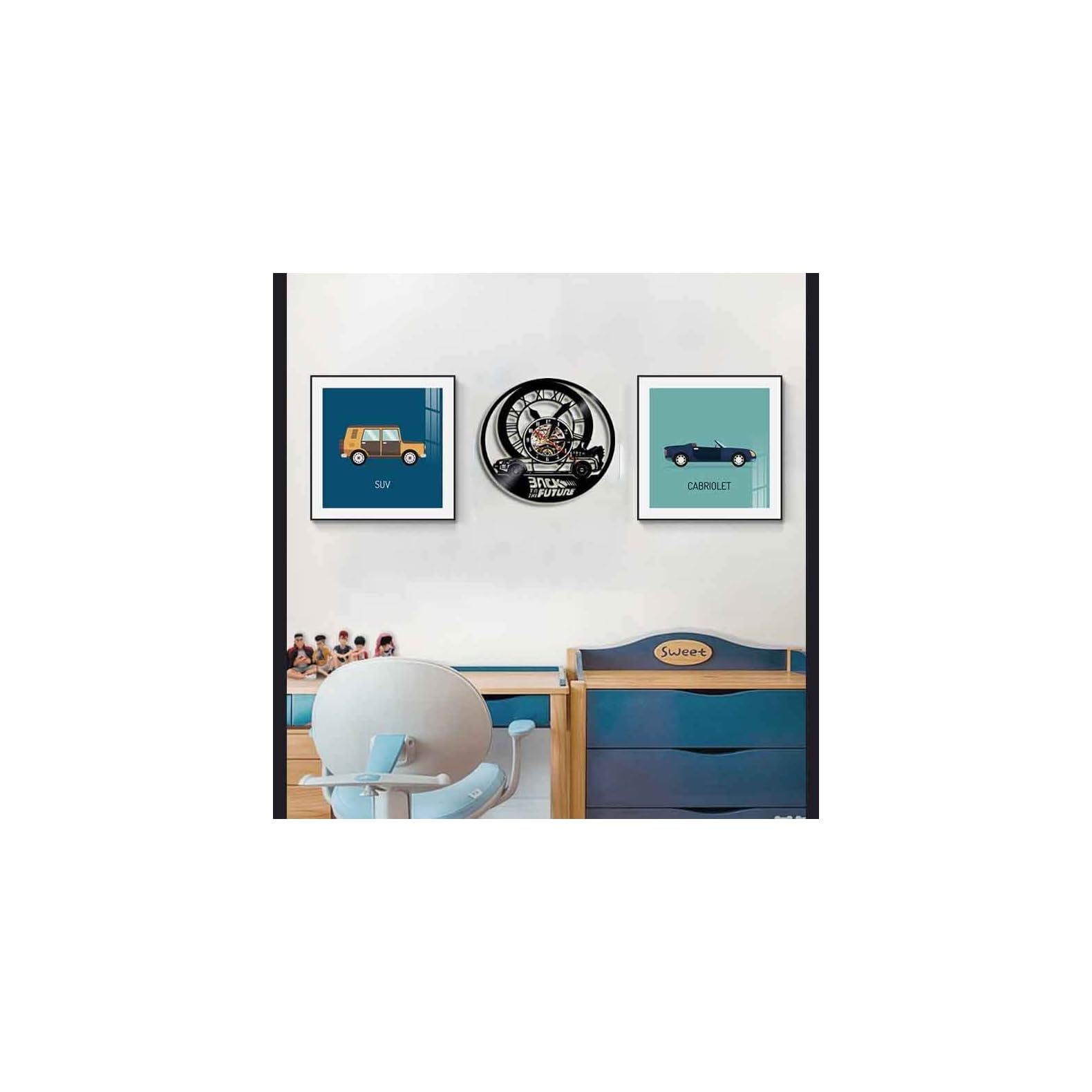 Eine weiße Wand mit zwei gerahmten Auto-Kunstdrucken und einer zentralen Zurück in die Zukunft-Schallplattenuhr.