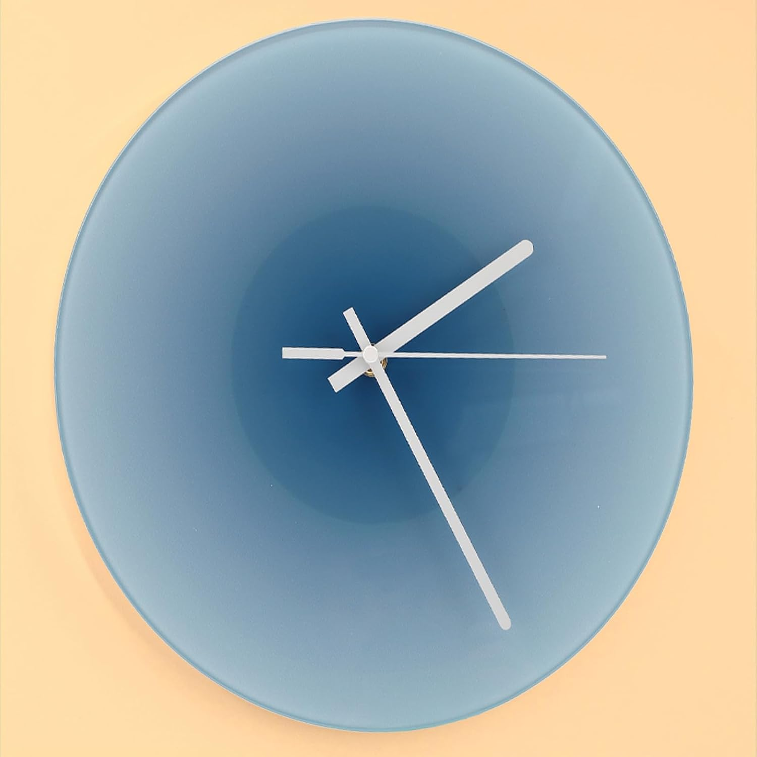 Blaue Wanduhr mit weißen Zeigern vor beigefarbenem Hintergrund.