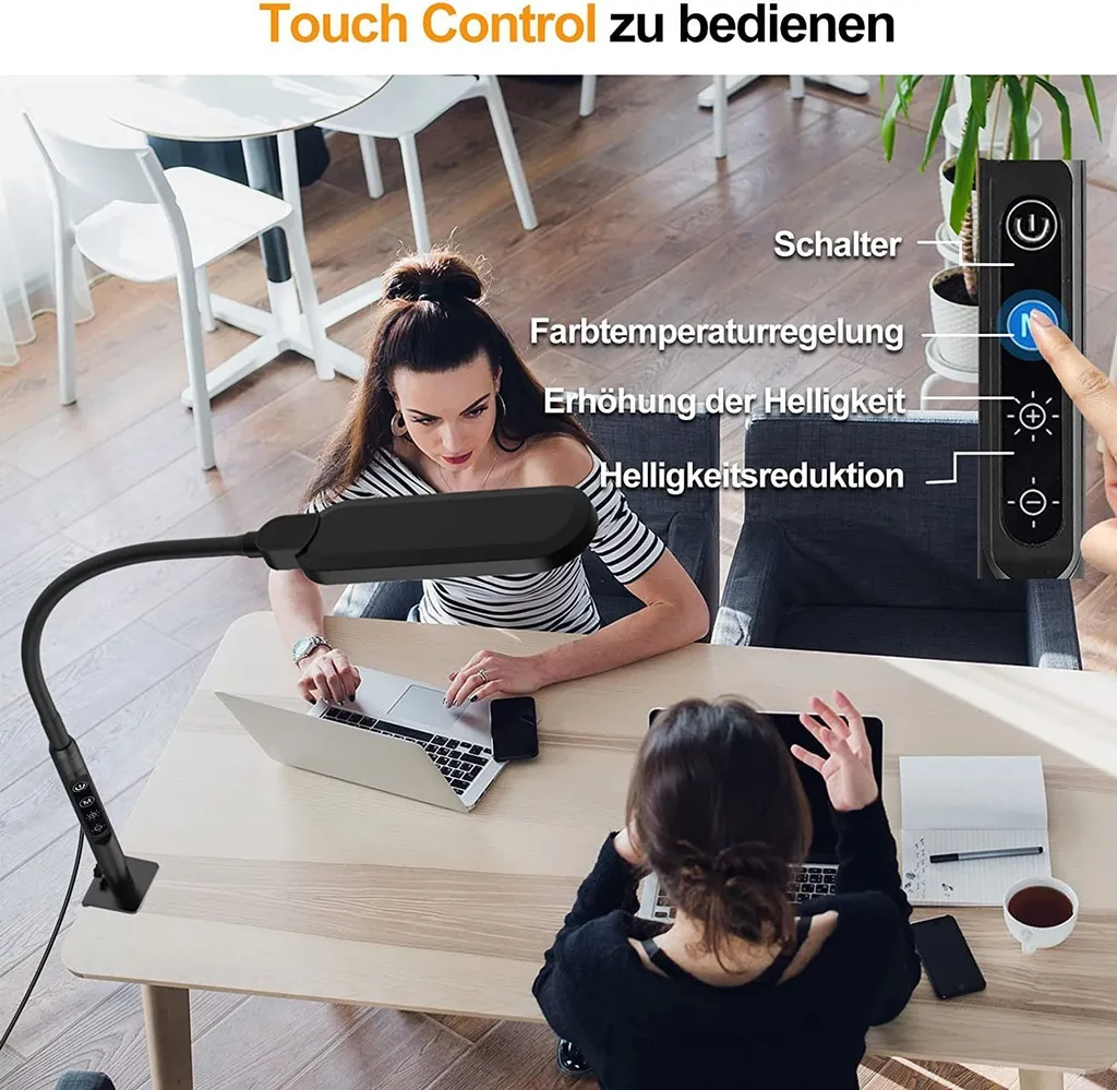 Zwei Frauen arbeiten an Laptops an einem Holztisch mit einer schwarzen LED-Schreibtischlampe.