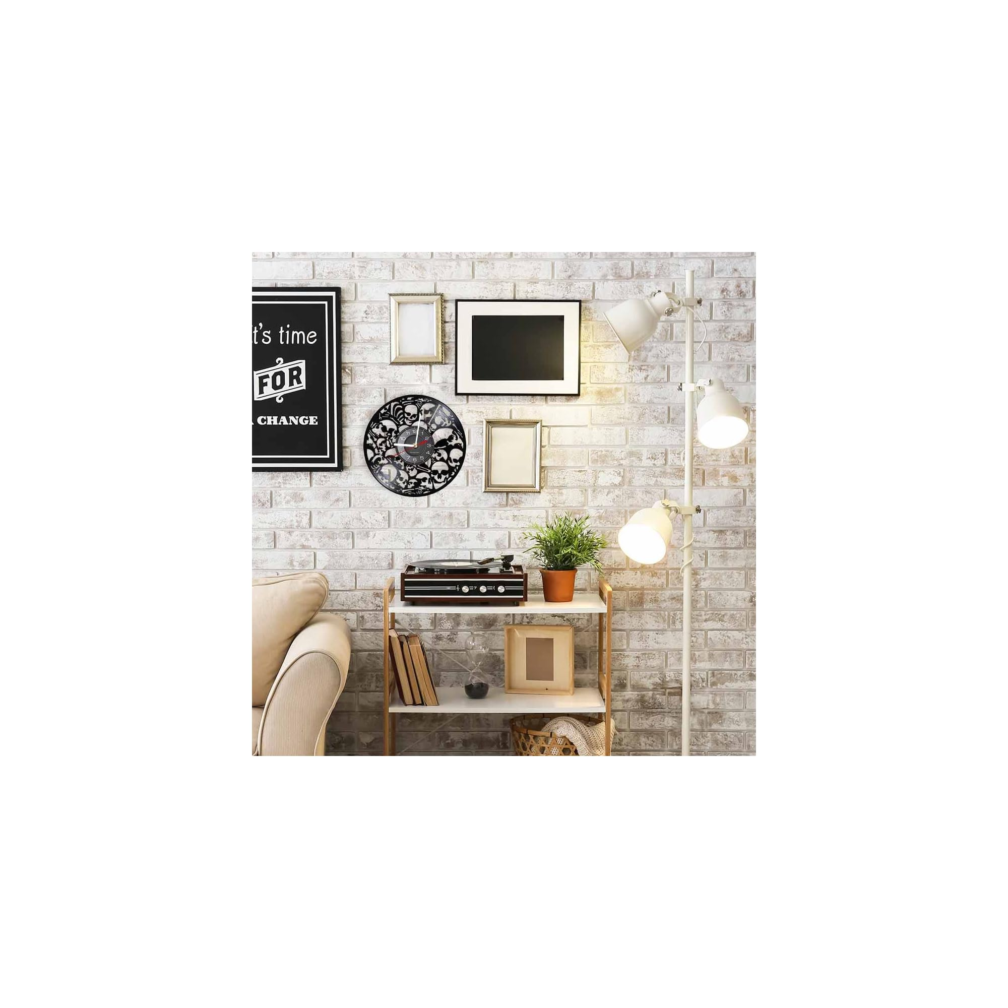 Wohnzimmer mit heller Backsteinwand, Regal, Turmuhr mit Totenköpfen, gerahmten Bildern und Stehlampe.