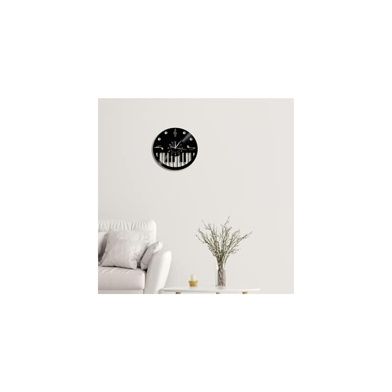 Eine schwarze Musikwanduhr mit Klaviertastenoptik hängt über einem Sofa in einem hellen Zimmer.