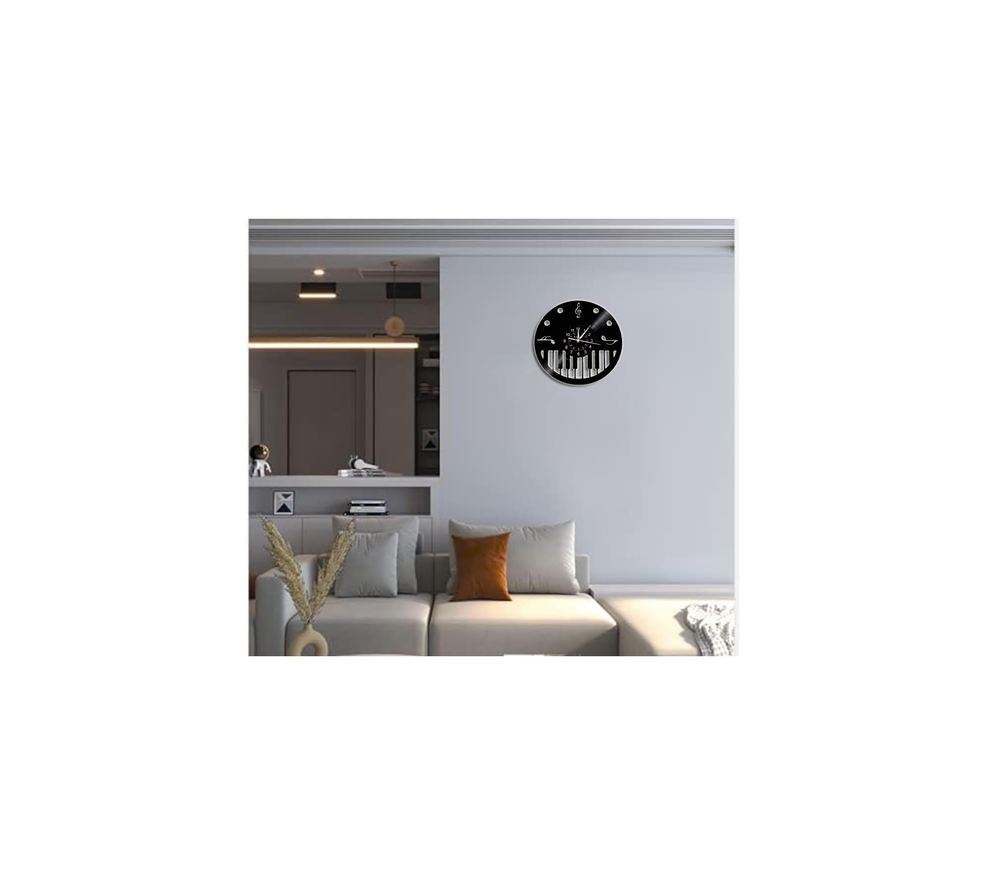 Wohnzimmer mit hellem Sofa, Kissen und einer runden Uhr mit Klaviertastenmuster an der grauen Wand.
