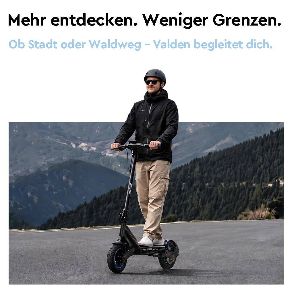 Ein Mann mit Helm und Sonnenbrille fährt auf einer asphaltierten Straße mit einem E-Scooter vor Bergen.