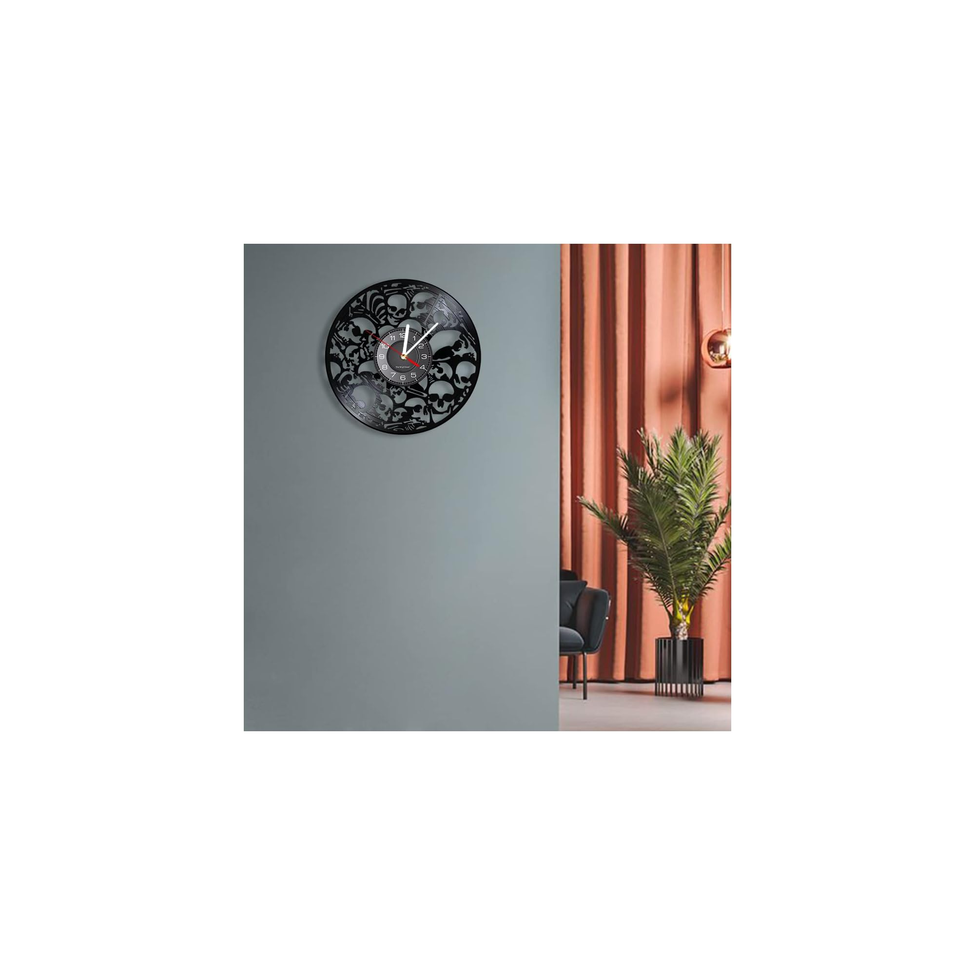 Eine totkopf-geusterte Wanduhr hängt an einer grauen Wand neben einem Zimmer mit orangen Vorhängen und Topfpflanze.