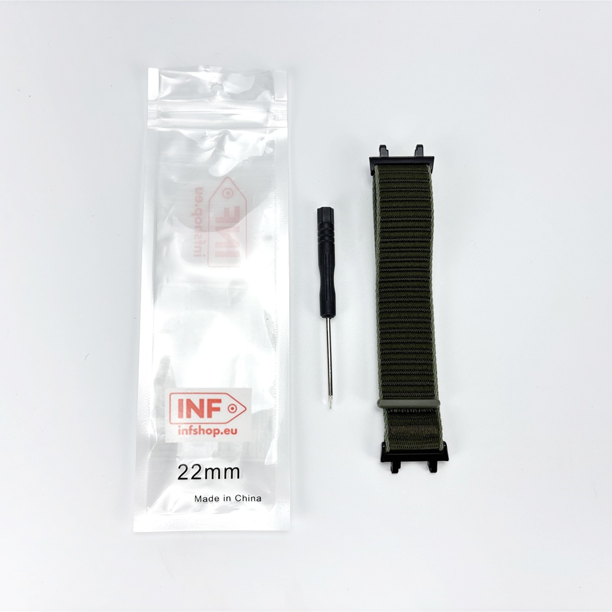 Ein grünes Uhrenarmband, ein kleiner Schraubenzieher und ein klarer Plastikbeutel auf weißem Hintergrund.