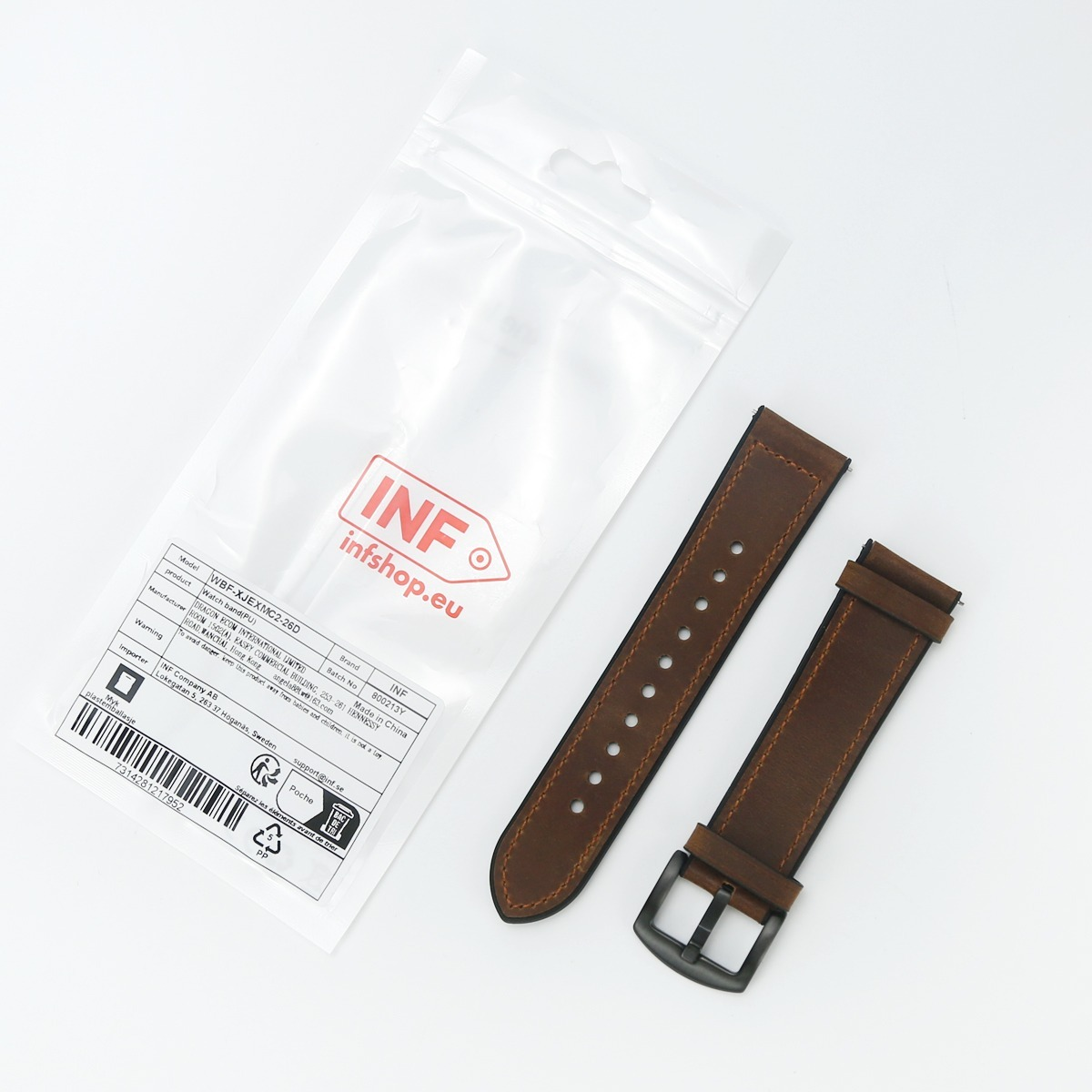 Braunes Leder-Uhrenarmband mit schwarzer Schließe neben einer Plastikverpackung mit Produktetikett.