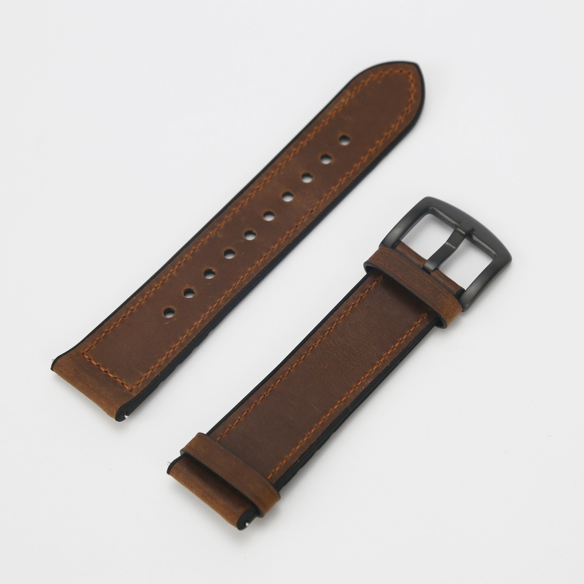 Zweiteiliges braunes Lederuhrenarmband mit einer schwarzen Metallschnalle auf hellem Hintergrund.