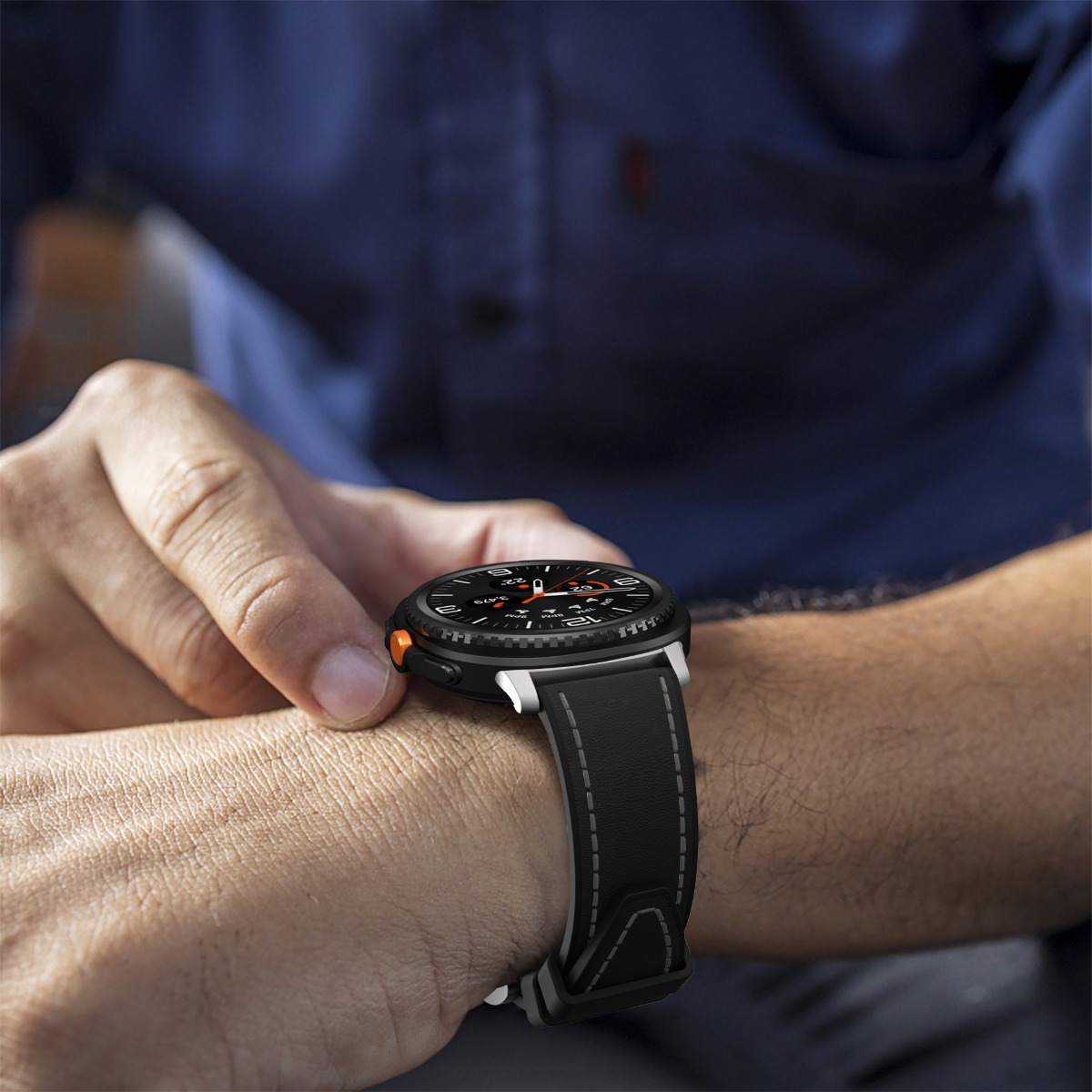 Eine Person trägt eine schwarze Smartwatch mit Lederarmband und tippt auf das Display.