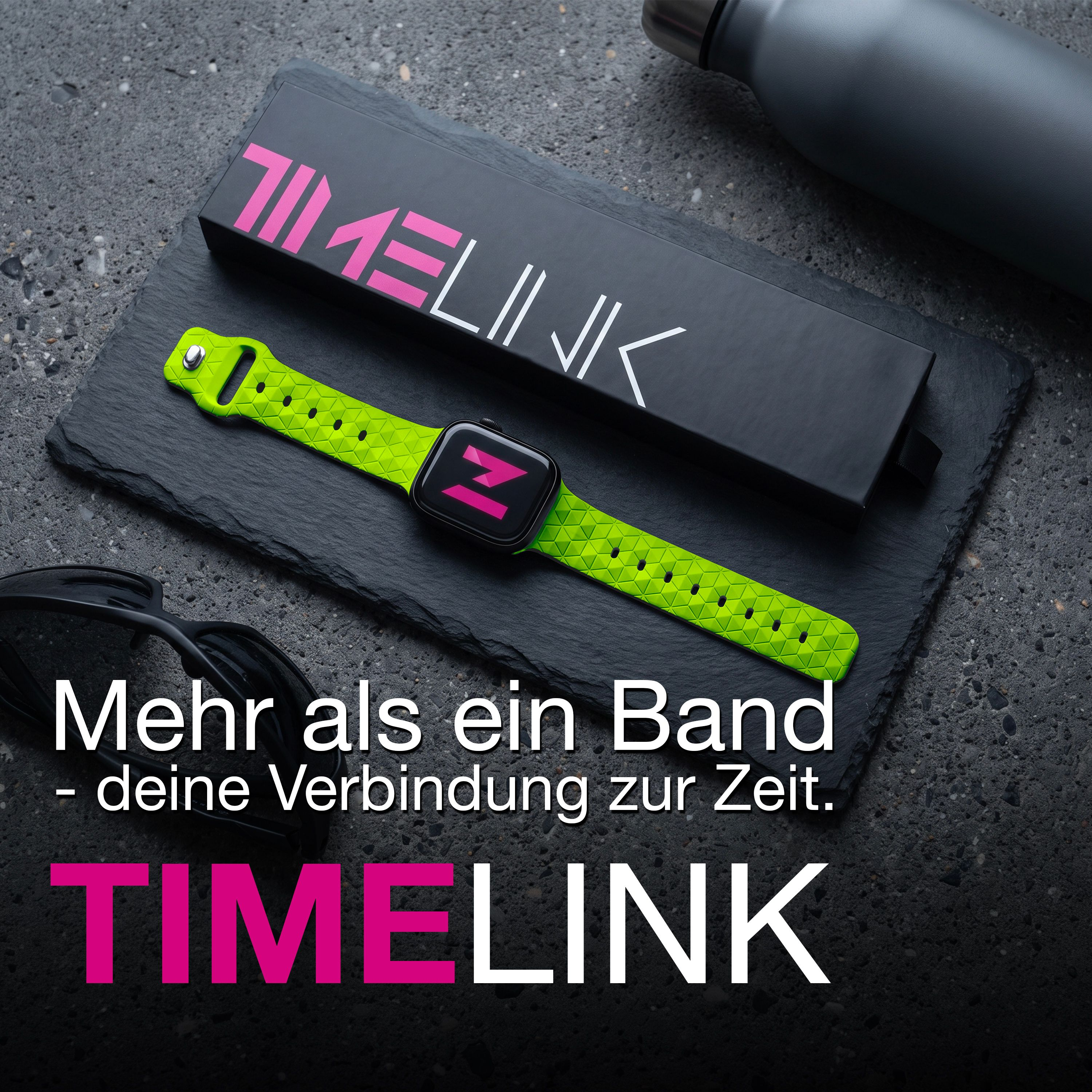 Ein limettengrünes Smartwatch-Armband, passende schwarze Schachtel und Sonnenbrille auf Schiefer.