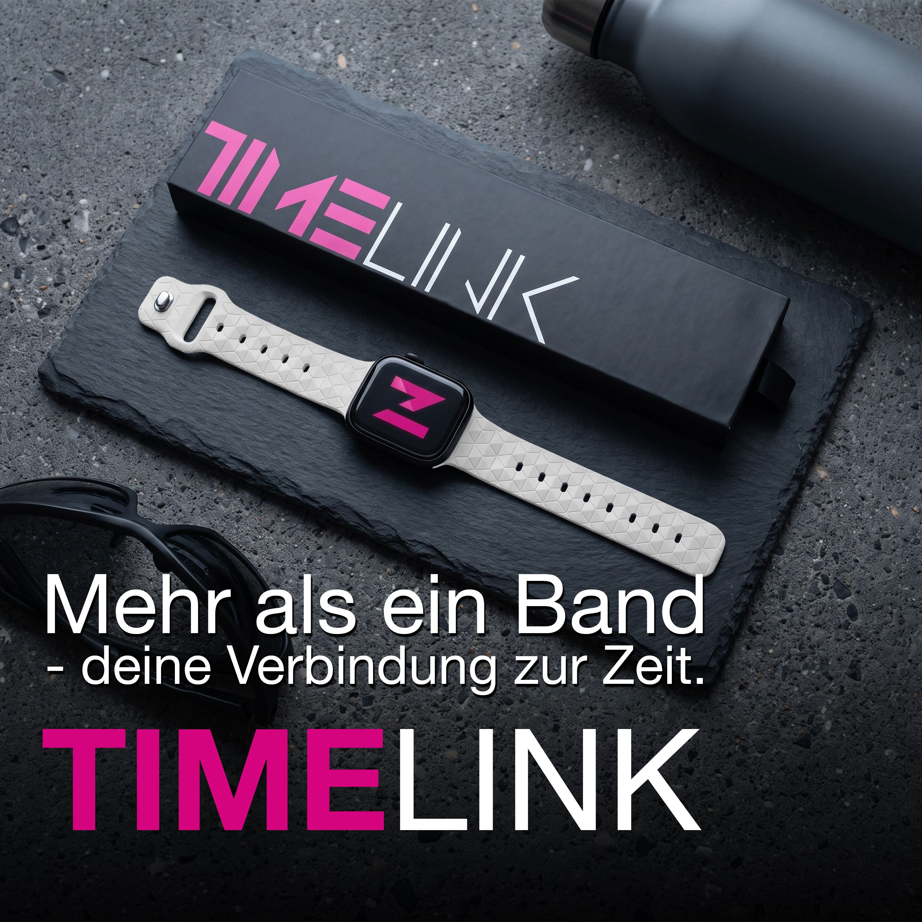 Eine Timelink Smartwatch mit weißem Band liegt auf Schiefer neben Box, Flasche und Sonnenbrille.