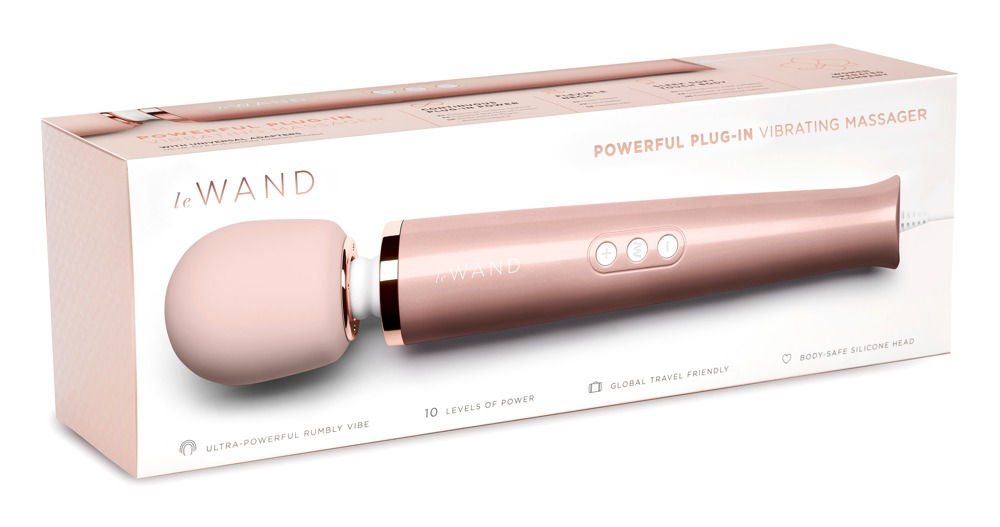 Ein roségoldener elektrischer Massagedstab liegt vor seiner Verpackung auf weißem Hintergrund.